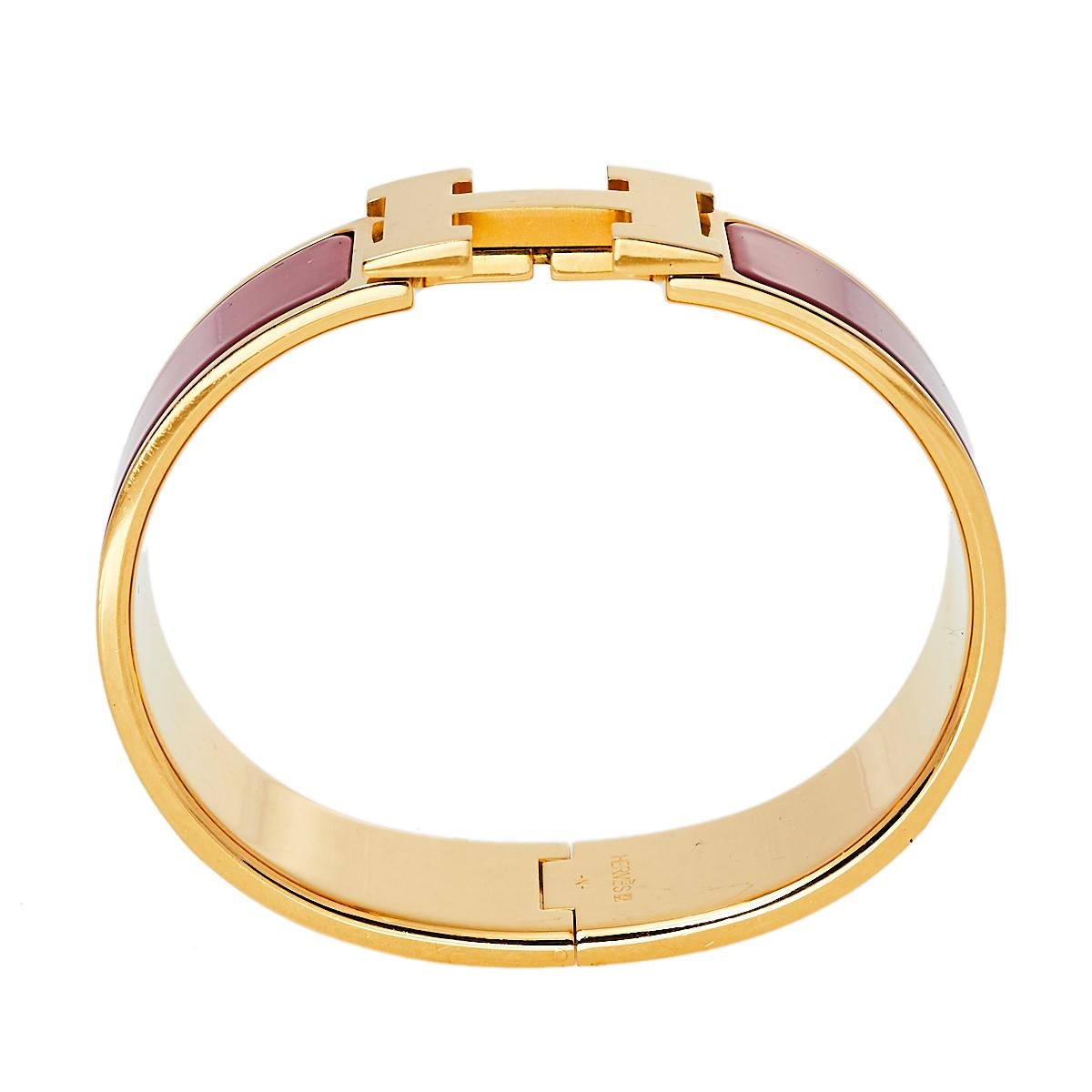 This elegant 'Clic Clac H' bracelet from the house of Hermès is designed in a wide silhouette. It features a gold-plated body with red enamel on it and the iconic 'H' logo swivel at the center. Wear it with your favorite watch or as a solo piece.

