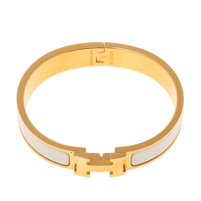 This bracelet embodies Hermès’ elegant craftsmanship with its gold-plated metal body and white enamel inlay. Featuring the iconic H logo of the fashion house at the front, this bracelet is the accessory to buy today!