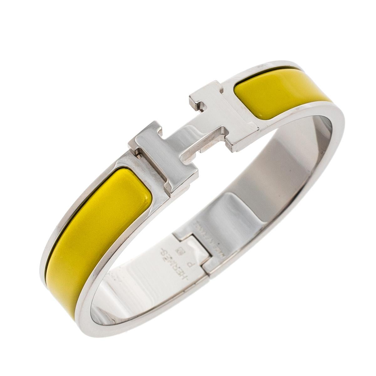 Adorn your wrist with this stunner of a bracelet from Hermes. The piece is from their Clic H collection, and it has been crafted from palladium-plated metal and designed with lime yellow enamel. This bracelet is complete with the iconic H to the