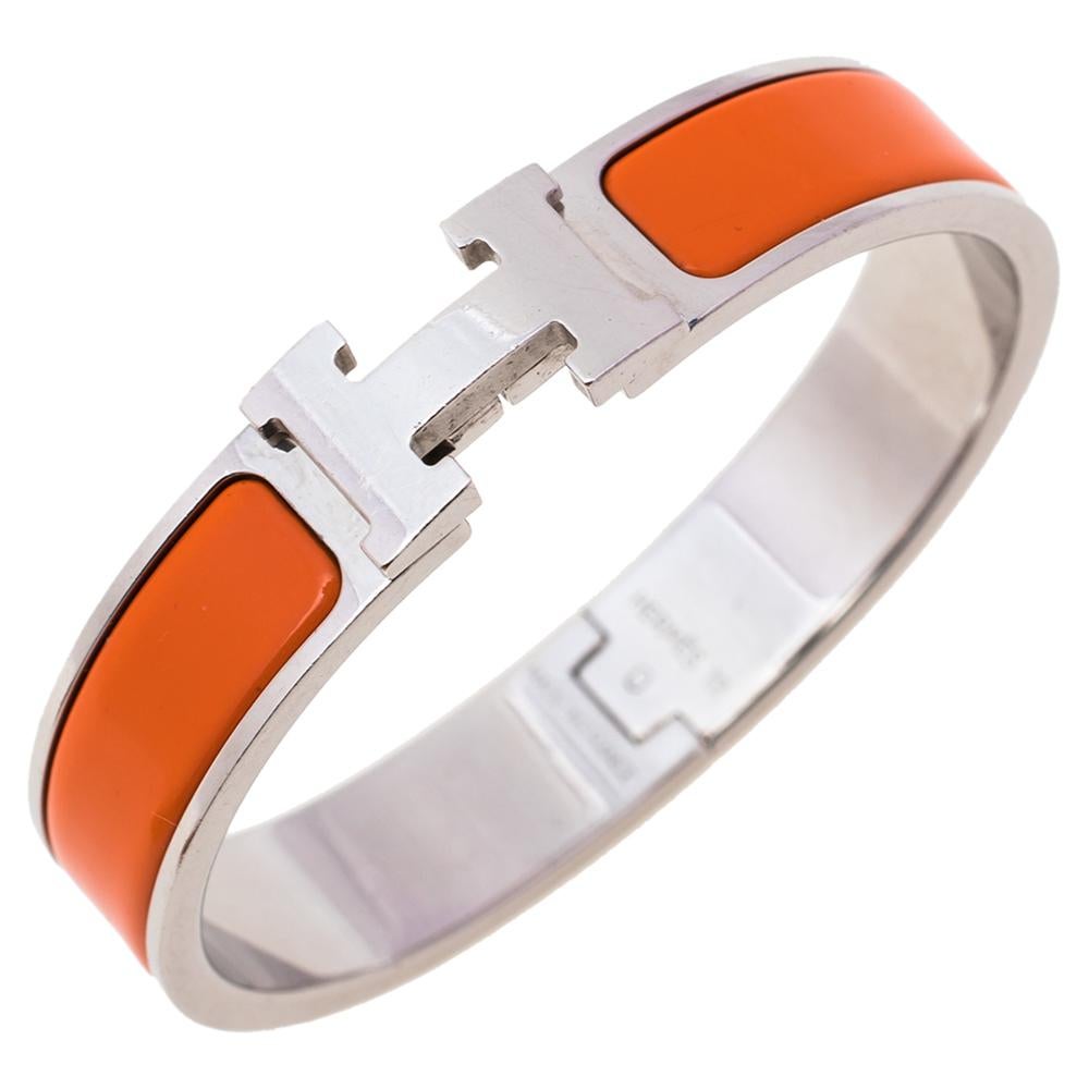 Adorn your wrist with this stunner of a bracelet from Hermes. The piece is from their Clic H collection, and it has been crafted from palladium-plated metal and designed with orange enamel. This bracelet is complete with the iconic H to the front.