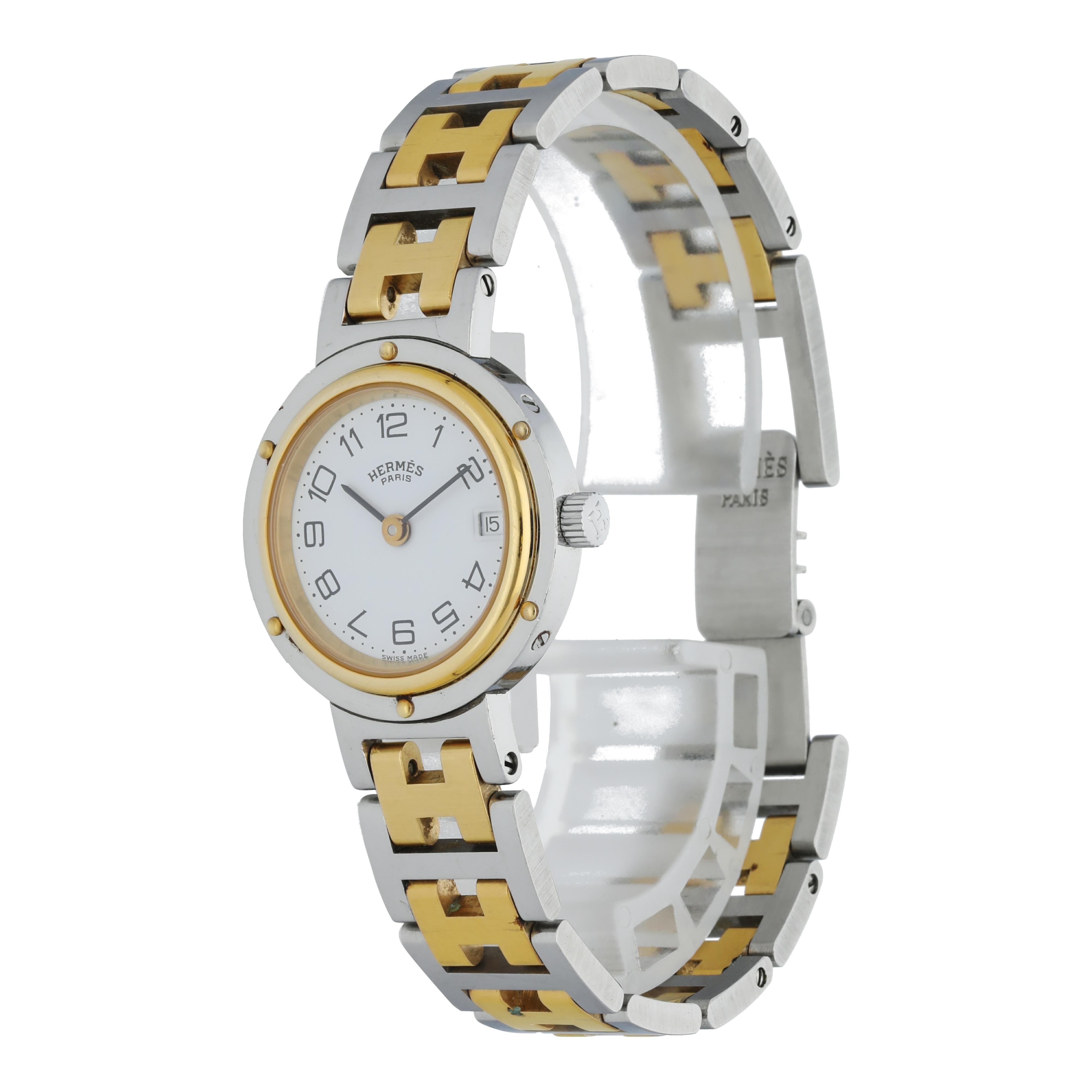 Hermes Clipper CL4.220 Ladies Watch.
24mm Stainless Steel case. 
Yellow Gold Stationary bezel. 
White dial with hands and Arabic numeral hour markers. 
Minute markers on the outer dial. 
Date display at the 3 o'clock position. 
Stainless Steel