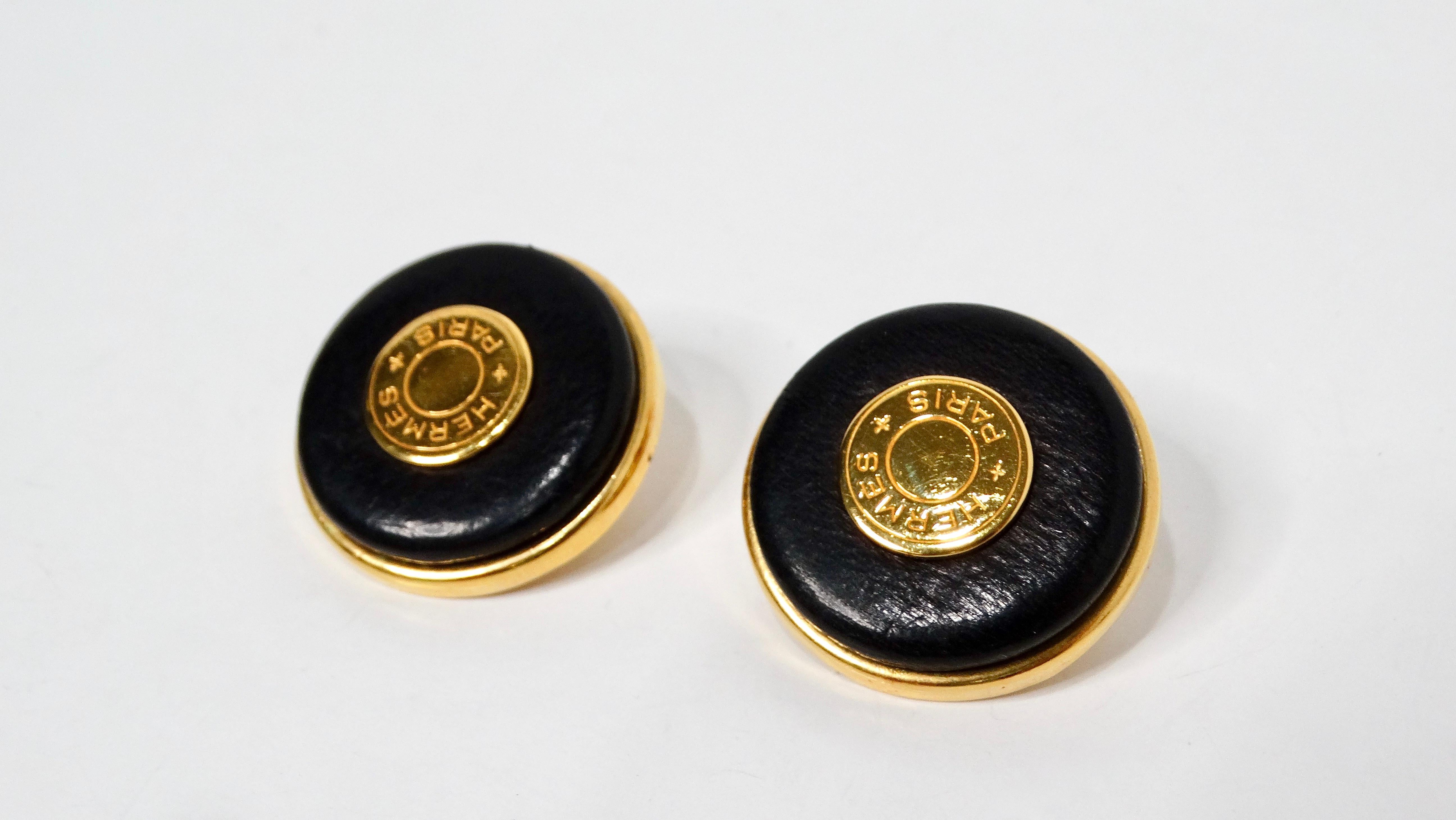 The Vintage Hermes Clou de Selle Black Leather & Gold Tone Clip-On Earrings are a sophisticated and timeless accessory that seamlessly blend luxury with everyday elegance. Crafted from smooth black leather, these earrings feature gold tone hardware