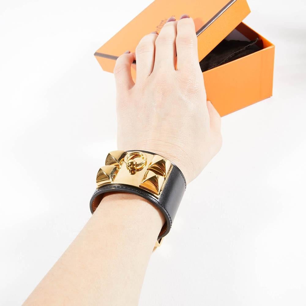 The cuff is from Maison HERMES. An essential and timeless model of the brand. It represents a dog collar here in black calfskin (box), studded in gold metal with fine gold. 
The cuff is like new because it has never been worn.  Its length is 20 cm,