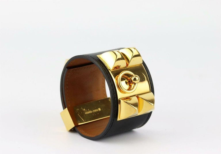 A request for a belt turned into the creation of the iconic Collier de Chien bracelet, this Hermès bracelet has been created from soft box calfskin leather with gold Medor pyramid studs, ring and adjustable closure.
Black leather.
Slide fastening at