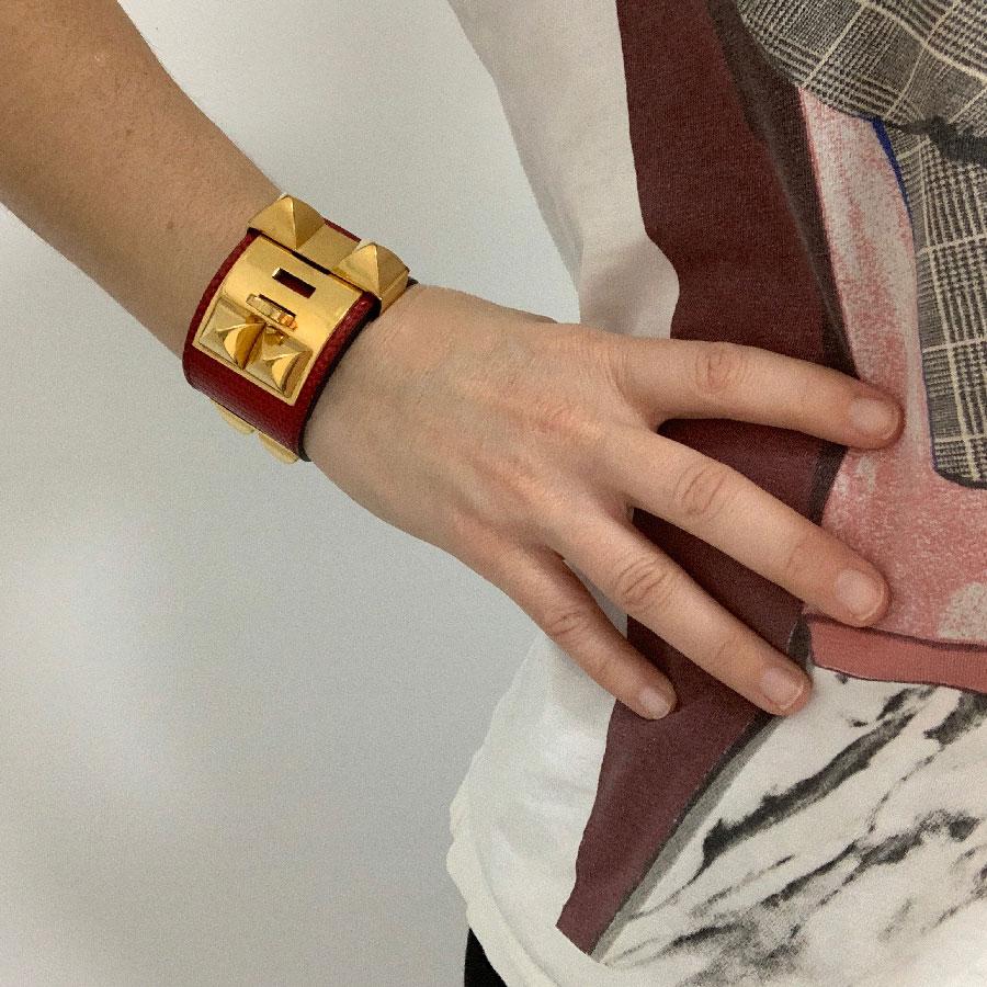 Beautiful HERMES Collier De Chien red lizard bracelet. Vintage jewel dating from 1990. Made in France.
HERMES cuff in rouge braise lizard is in good condition. The gold plated hardware presents micro scratches of use. Leather wears marks of use,