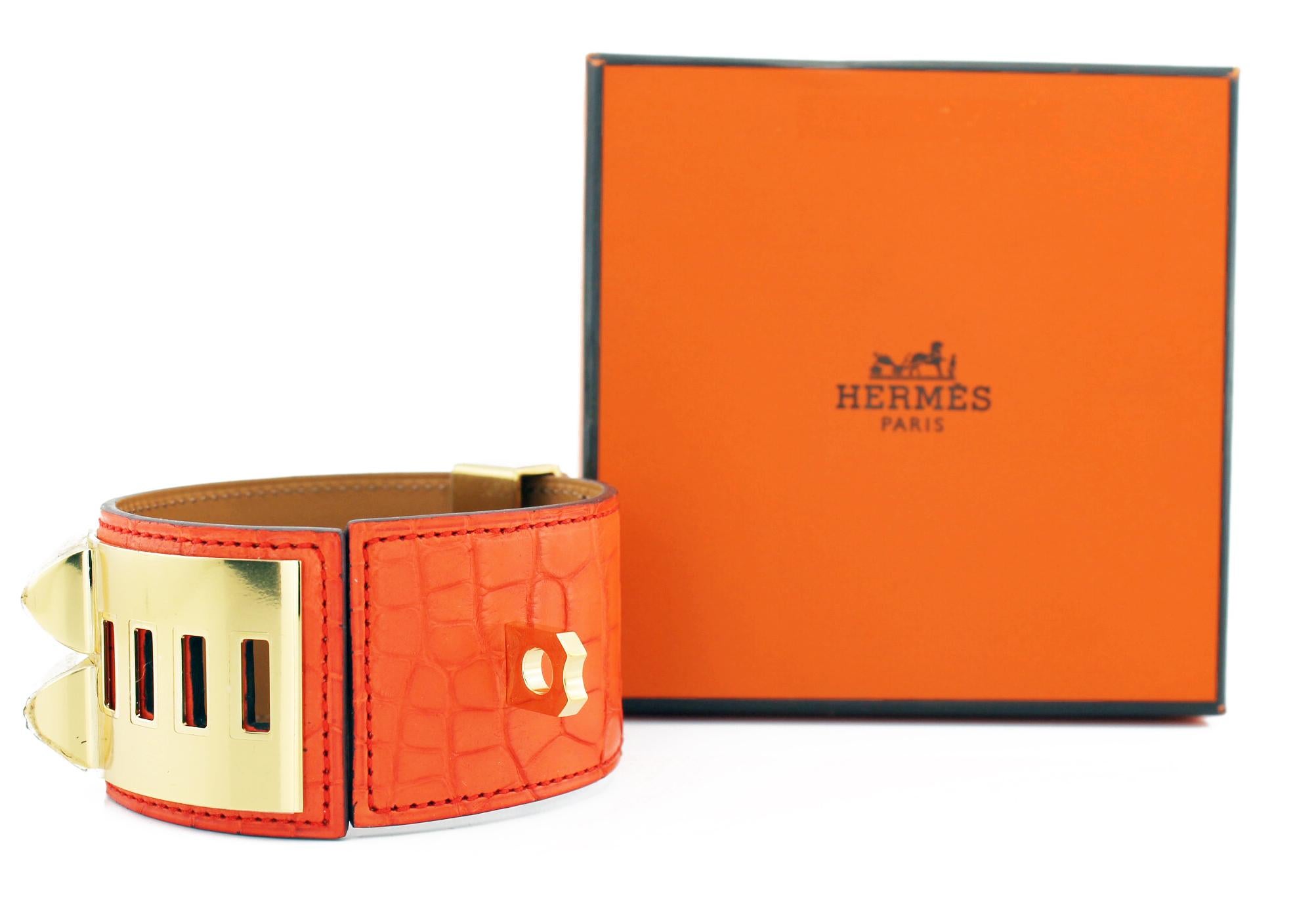 Hermes Collier De Chien Crocodile Cuff
Orange crocodile cuff with gold plated pyramid studs and ring
New with stickers.
Original pouch and box
Size: Small
RRP £1,700