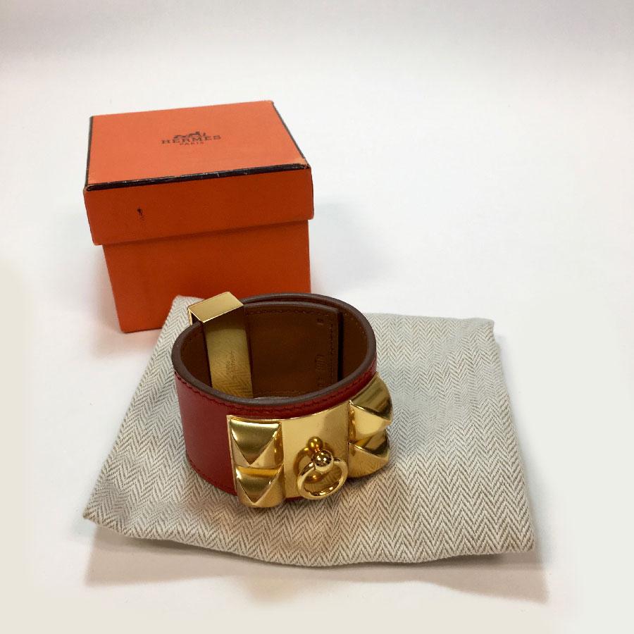 Hermès Collier de Chien cuff in blood-colored calfskin and golden jewelry. 
Mint condition.
Letter R in a square (2014). Made in France. Size S.
Letter S from private sales.
Protective films are present on the golden jewelry.
Dimensions: total