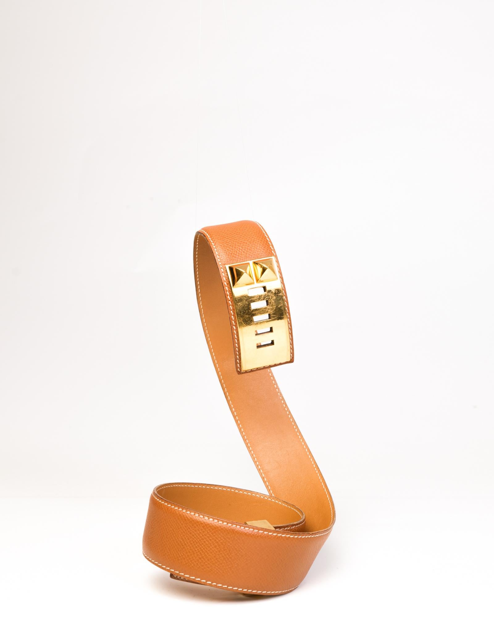Hermès Collier de Chien belt made with a Gold Epsom leather with white contrast stitching and gold tone hardware.

COLOR: Tan
ITEM CODE: square+
MATERIAL: Leather
MEASURES: L 31” W 1.5”
COMES WITH: Dust bag
CONDITION: Good - belt shows stretching