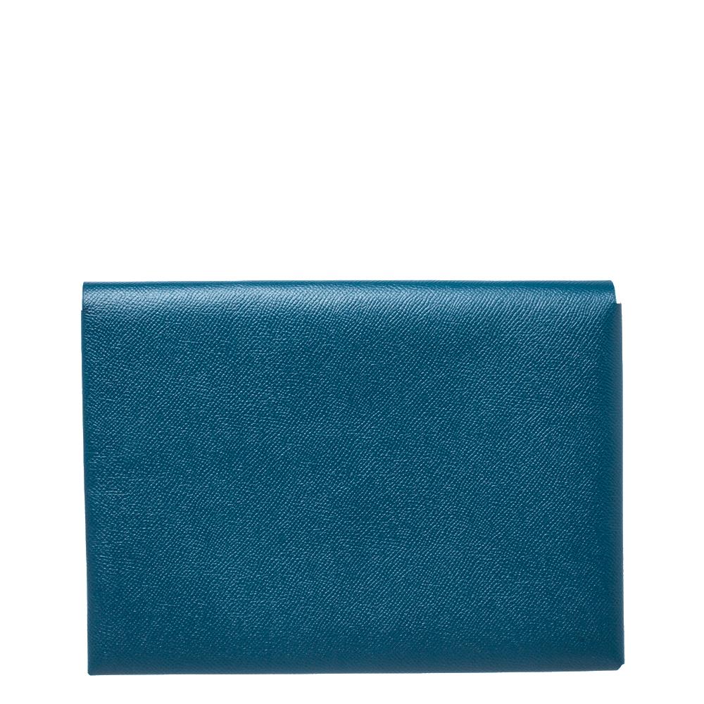 Add a touch of minimized elegance when you style this Hermes Calvi pouch with your favorite accessories. Much coveted amongst the contemporary fashionistas, this blue pouch has a simple silhouette and is secured with a snap button fastening. It is