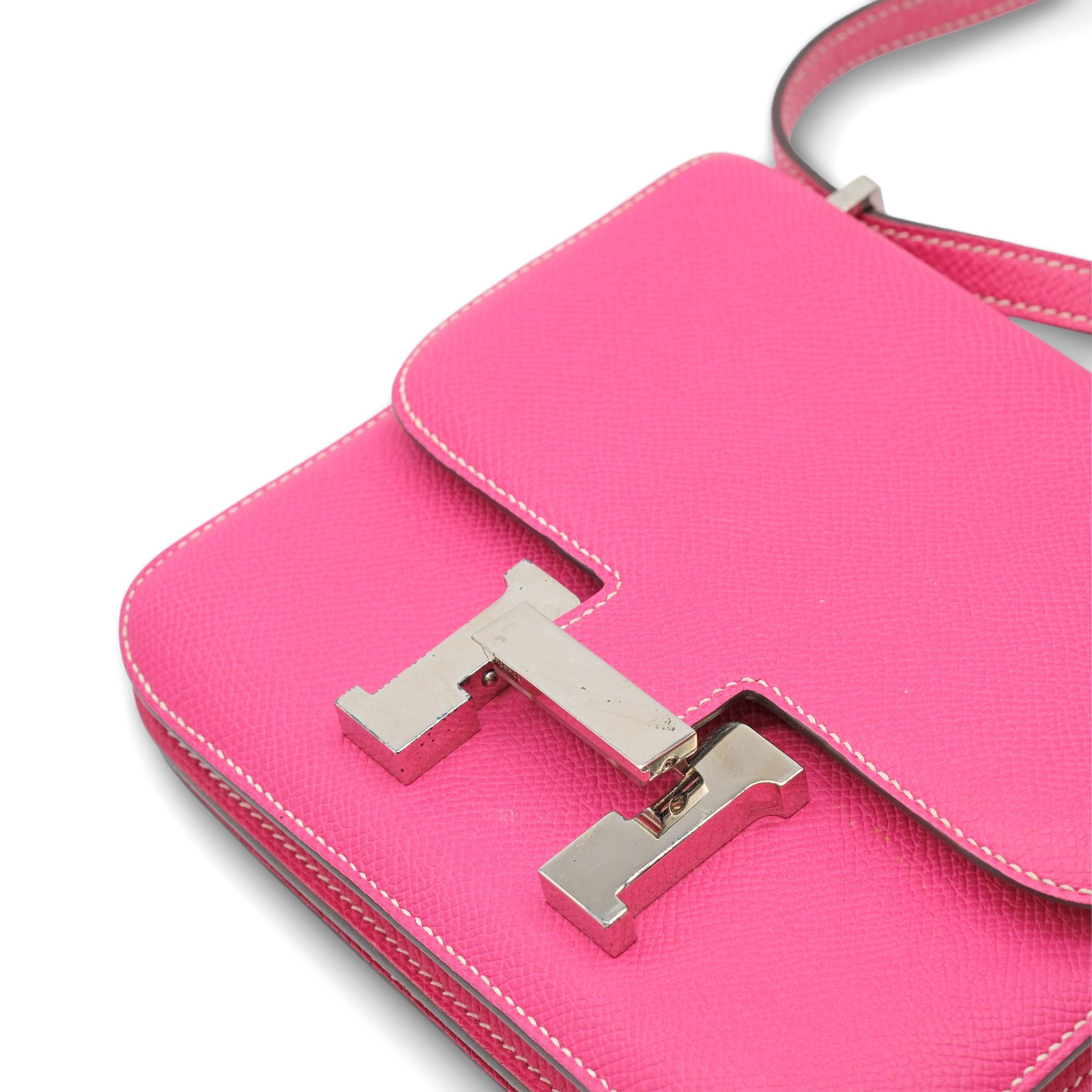 The Hermès Constance 18 Mini in Fuchsia Epsom Leather is a luxurious and vibrant accessory, crafted from durable scratch-resistant Epsom leather. The bright fuchsia pink color adds a striking pop, while the polished silver hardware provides a