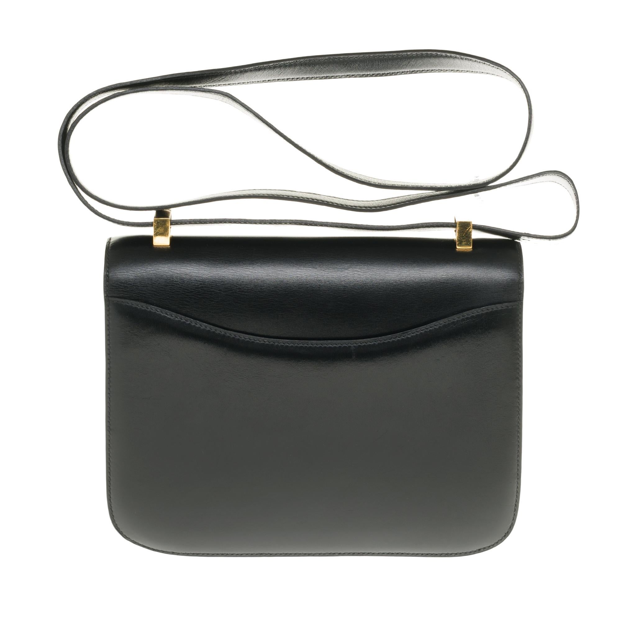 Stunning Hermes Constance Handbag 23 cm in black box leather, gold metal trim, black leather transformable handle allowing a hand or shoulder support.

Closure marked H on flap.
A patch pocket on the back of the bag.
Lining in black leather, a