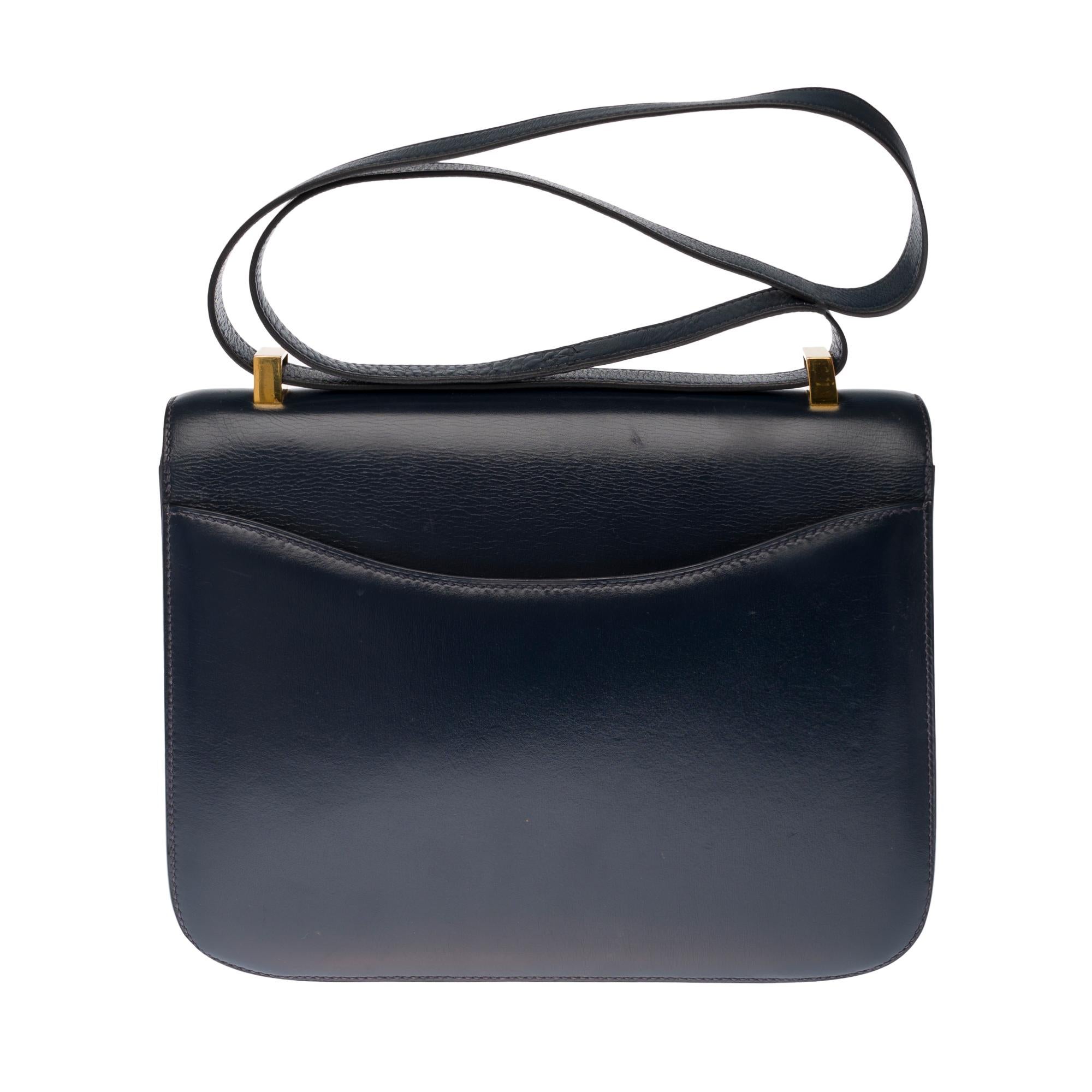 Splendid Hermes Constance 23 cm handbag in navy blue box, gold metal hardware, transformable handle in navy leather allowing a hand or shoulder.

Closure with H buckle on flap.
A patch pocket on the back of the bag.
Lining in navy leather, one zip