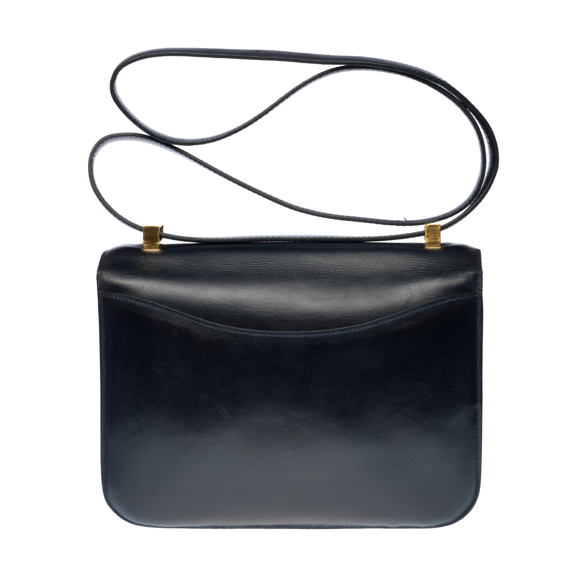 Splendid Hermes Constance 23 cm vintage handbag in navy blue box, gold metal trim, transformable handle in navy leather allowing a hand or shoulder support.

Closure with H buckle on flap.
A patch pocket on the back of the bag.
Lining in navy