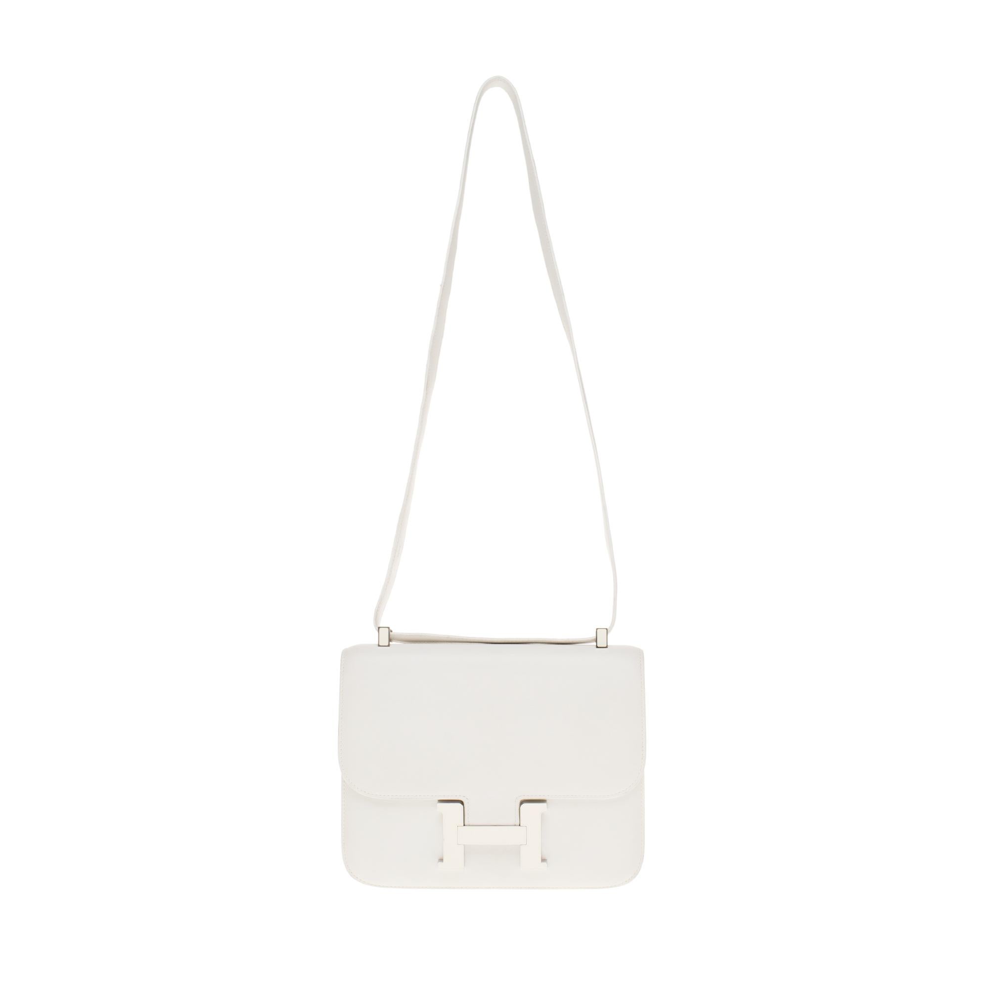 This is an exceptional piece essential for your summer:

Splendide & Rare Hermes Constance 23 cm handbag in white calfskin leather with gold hardware and enamel , white leather handle that can be easily carried by hand or shoulder.

H-shaped closure