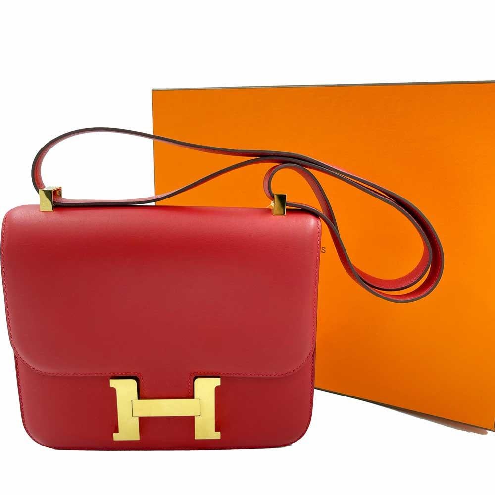 HERMES Constance Bag in Rouge Casaque swift Leather.
It has a double bellows. 
In very good condition, only the golden H has micro scratches. It is made of Swift leather. 
It has a tiny mark on the corner see photo.
Dimensions: 23 x 18 x 5 cm. Made