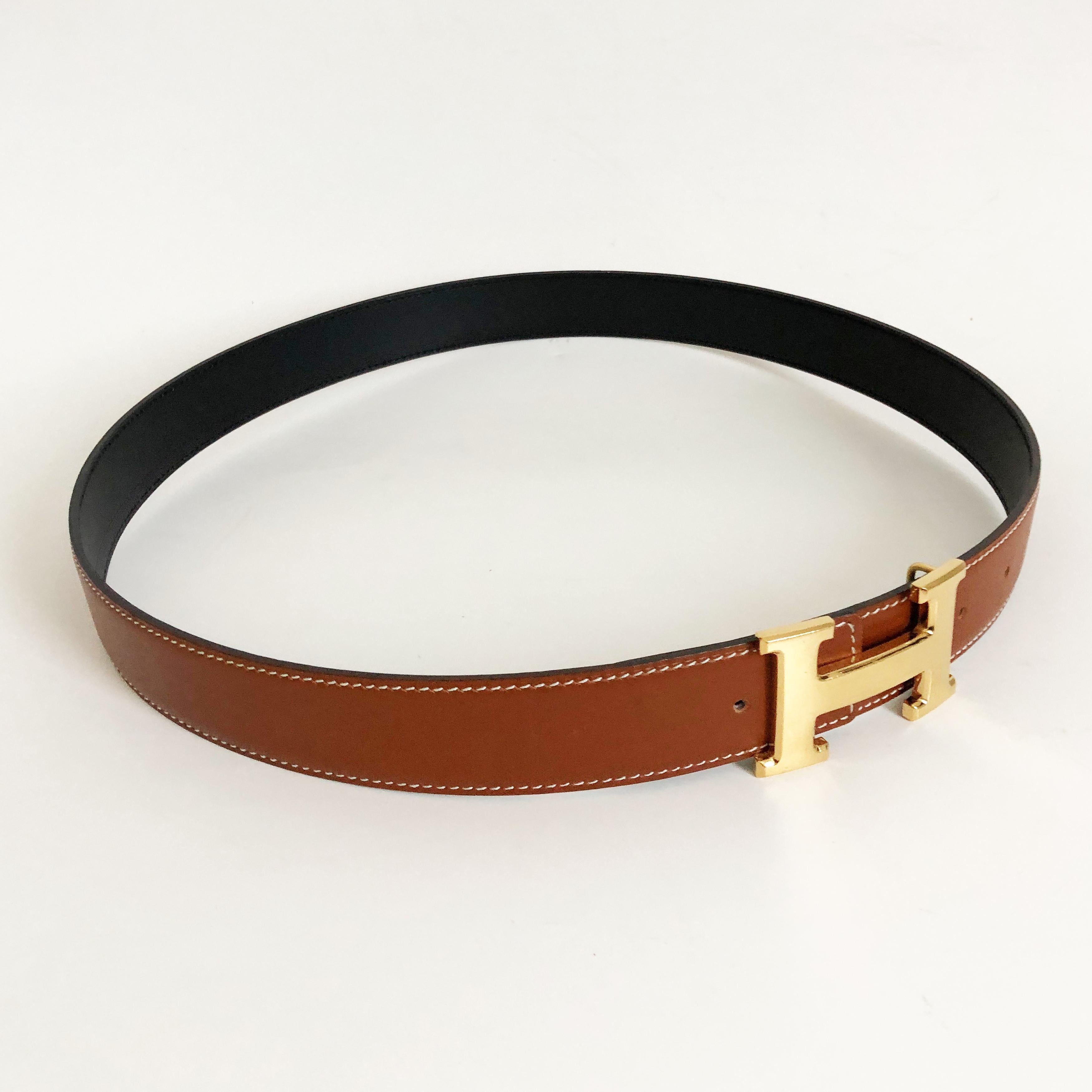Hermes Constance Gold Buckle & Reversible Belt Strap, size 75cm (29.9in). Strap reversible between noir (black) and saddle (natural). Stamped Q in a square (2013 year of production). Gold metal buckle is stamped HERMES. Preowned with signs of wear: