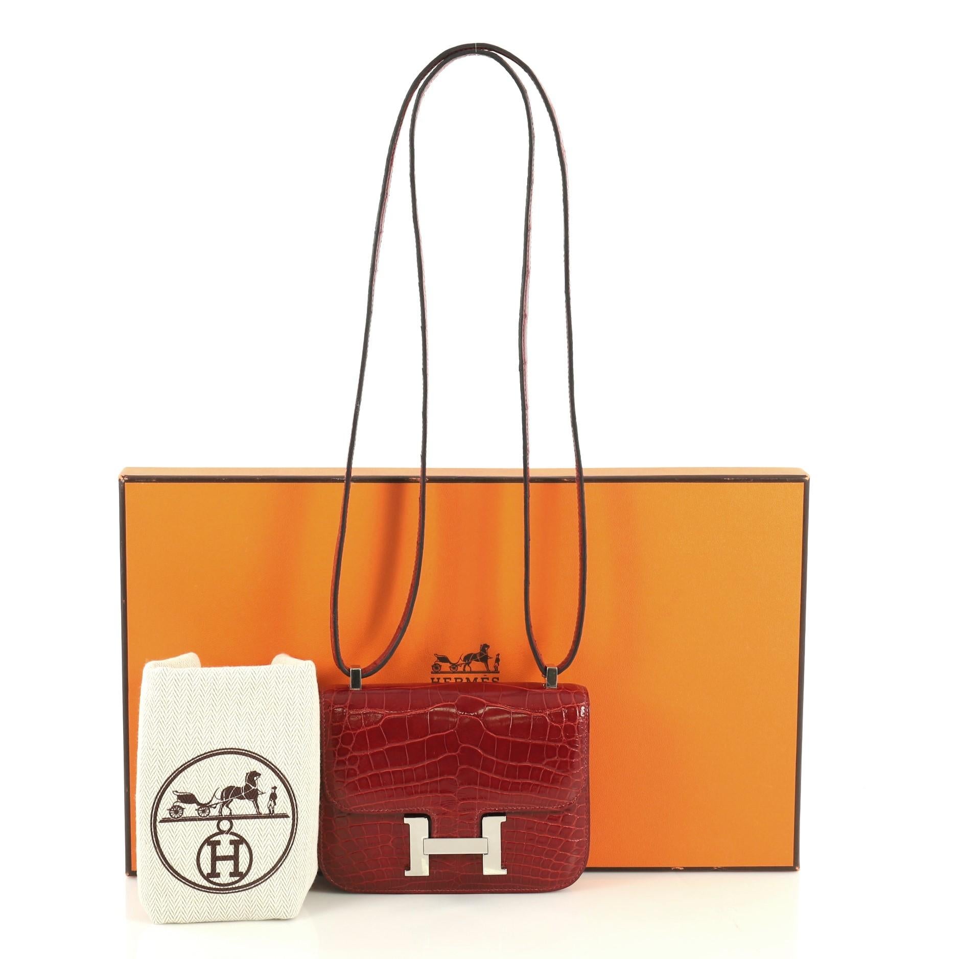 This Hermes Constance Handbag Shiny Alligator 14, crafted from genuine Rouge H red Shiny Alligator, features large signature 