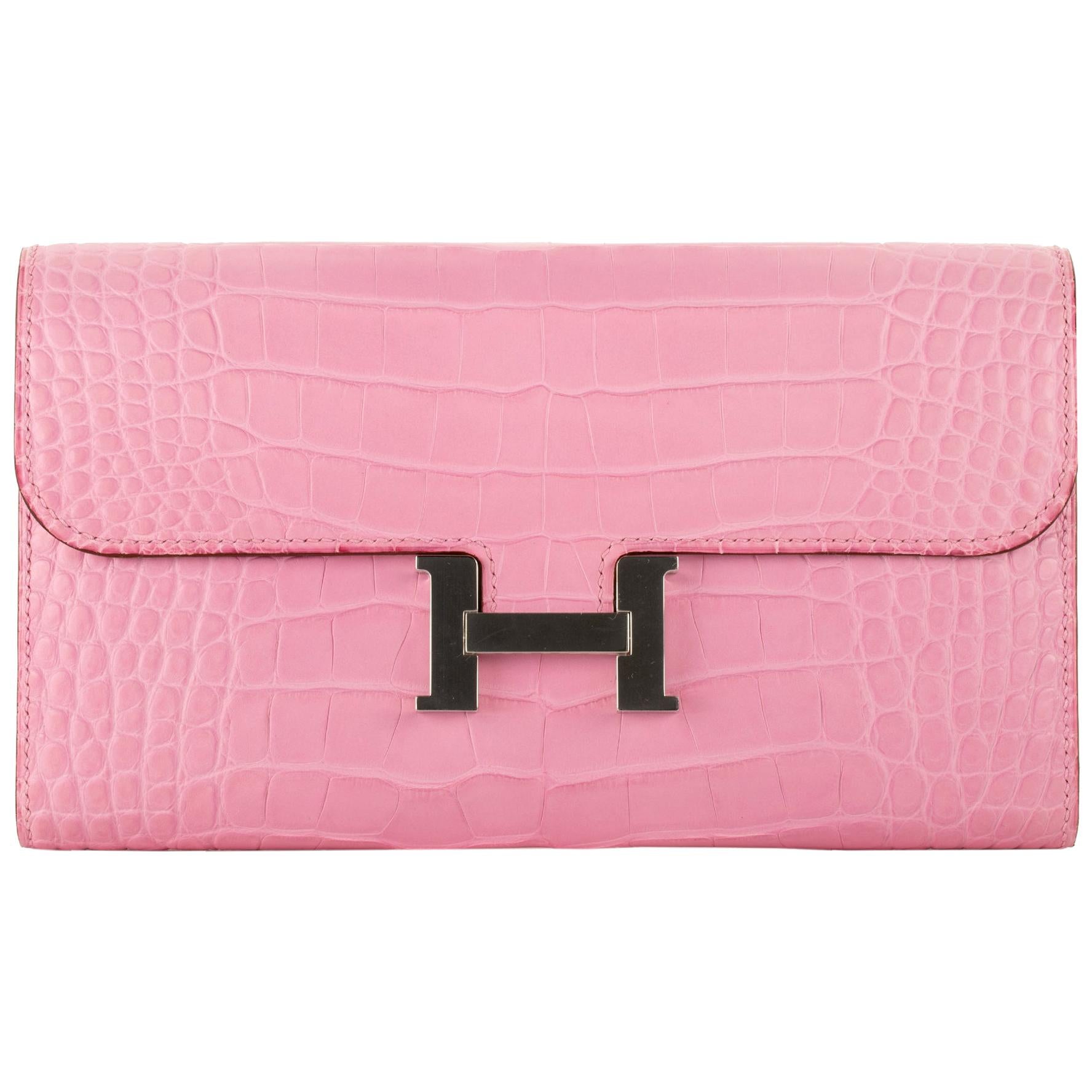 Brand: Hermès 
Style: Constance Wallet 
Size: 20.5 L x 13 H x  2 D cm
Color: Bubblegum
Leather: Matte Alligator
Hardware: Palladium
Stamp: 2020 D
Other: 12 credit card slots, 2 bill pockets, zipped change purse, external pocket and palladium plated