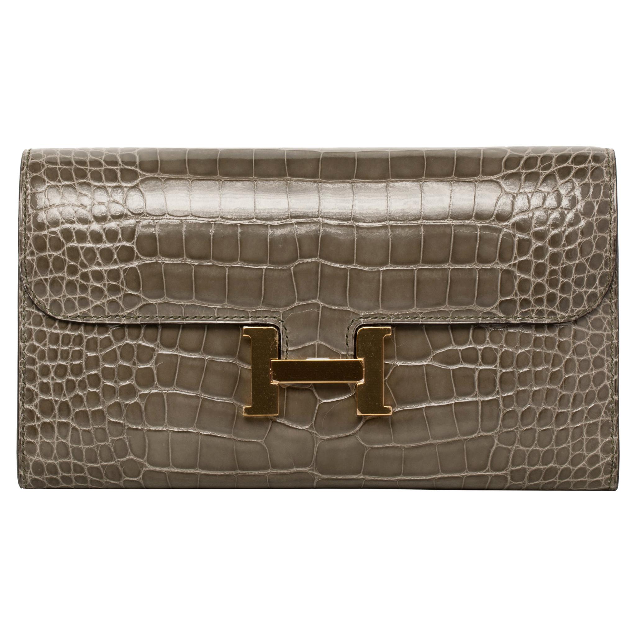 Marchio: Hermès 
Stile: Portafoglio Constance 
Dimensioni: 20,5 L x 13 H x  2 D cm
Colore: Gris Tourterelle 
Pelle: Alligatore lucido
Ferramenta: Oro
Francobollo: 2017 A
Altro: 12 scomparti per carte di credito, 2 tasche per banconote, portamonete