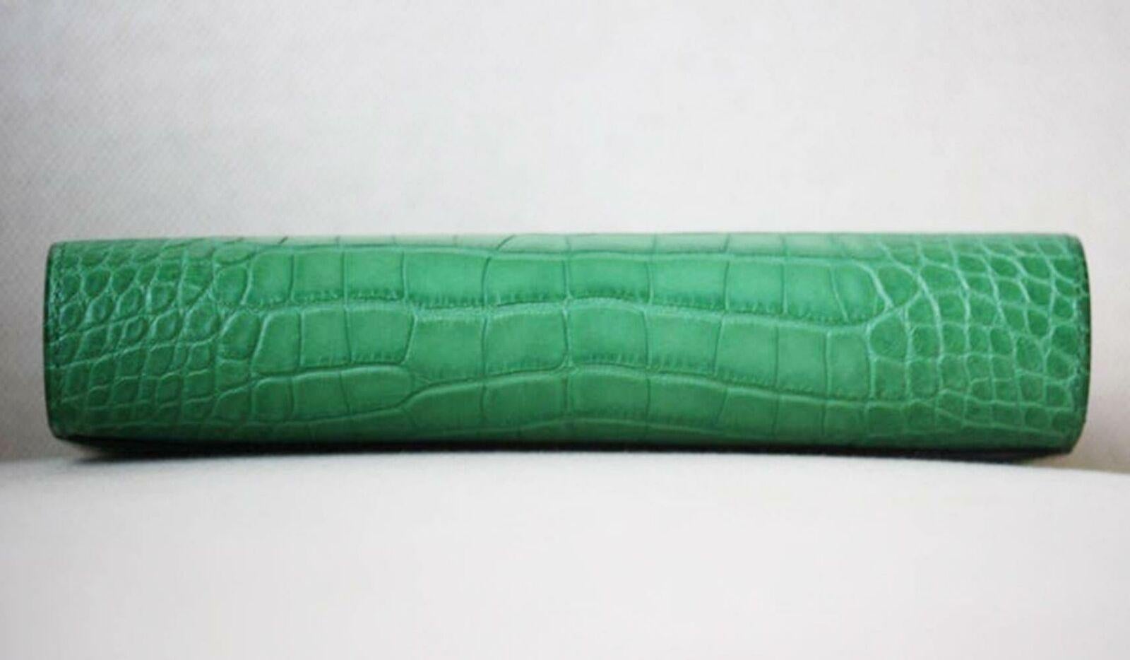 Long wallet in matte patina alligator in light green with 12 credit card slots, 2 bill pockets, zipped change purse, external pocket and palladium ’H’ tab closure.
Some protective plastic still attached.
Comes with dustbag and comes.
Dimensions: L