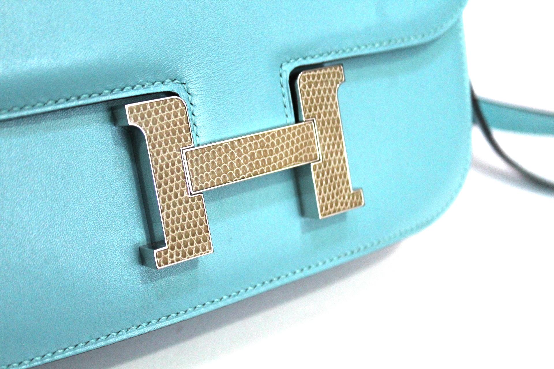 Pretty and original Hermes Constance small shoulder bag in Swift blue du nord leather, palladium inserts, convertible shoulder strap in blue leather to be worn on the shoulder or over the shoulder. The buckle is covered in python leather.