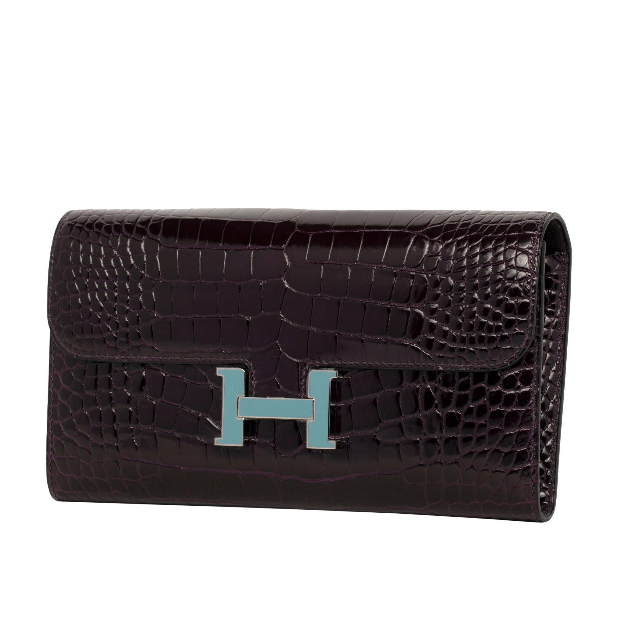 The Hermes Constance Wallet in Prunoir Shiny Alligator with Palladium and Blue Saint Cyr Enamel Hardware is a testament to luxury and style.

This meticulously crafted wallet combines the exquisite Prunoir Shiny Alligator leather with the striking