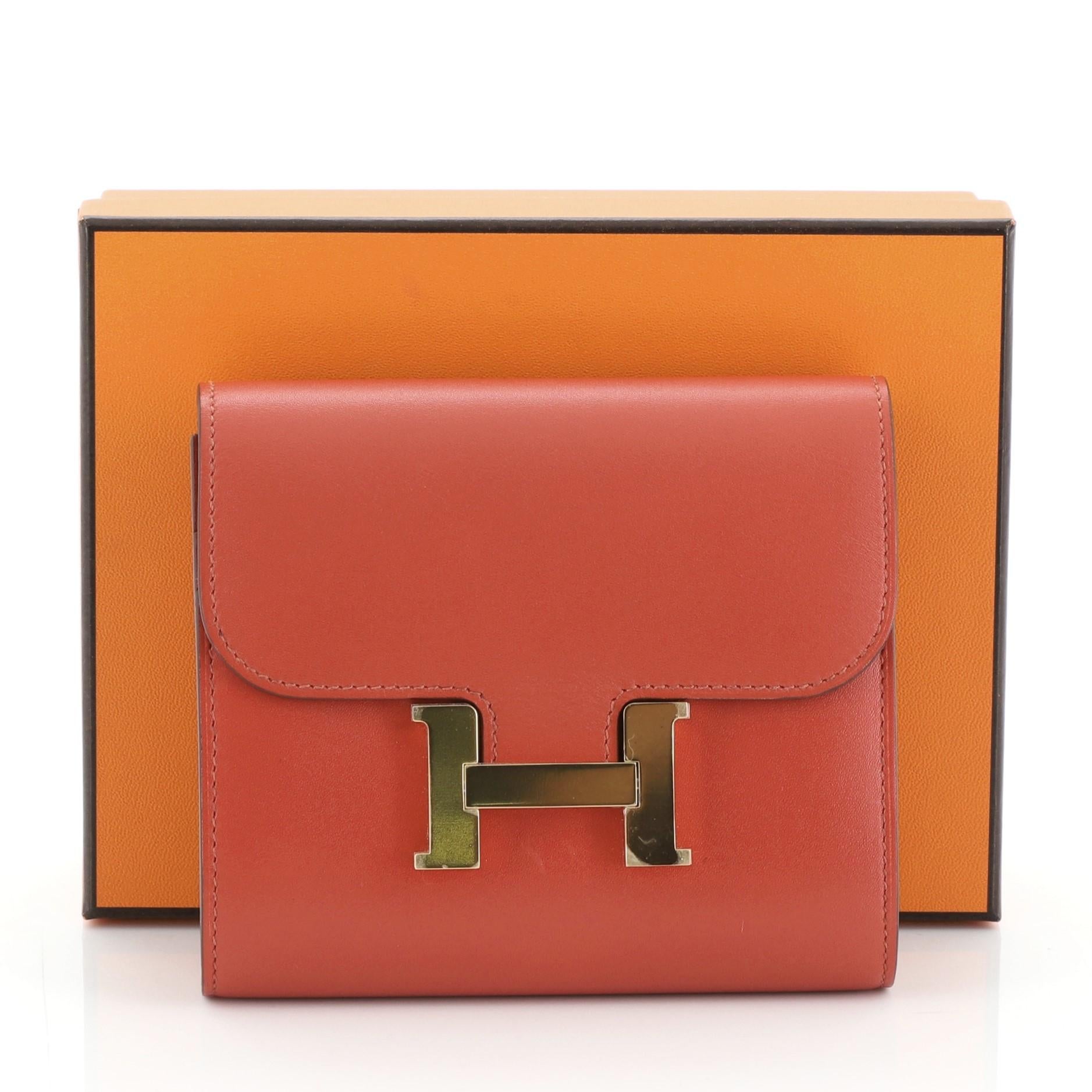 This Hermes Constance Wallet Swift Compact, crafted from Sanguine orange Swift leather, features a frontal constance 