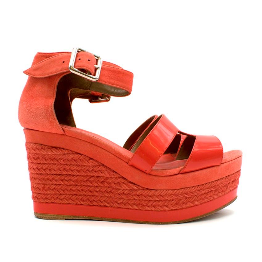 Hermes Bright Coral Platform Espadrille Wedges

- Patent leather classic Hermes logo shape shoe strap
- Silver tone metal ankle buckle fastening 
- Patent leather trip at bottom of platform

Material
- Suede
- Patent leather
- Leather sole

Made in