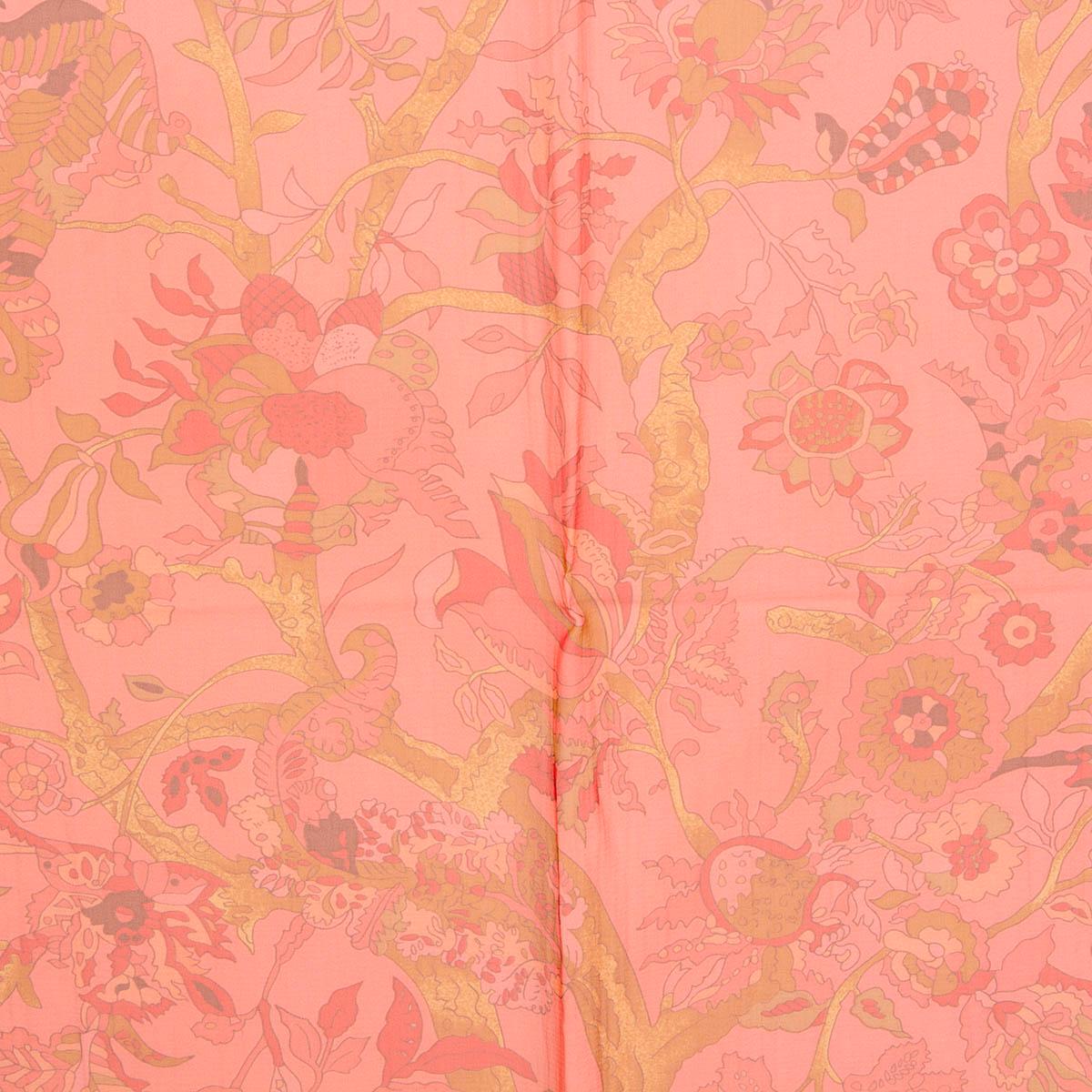 100% authentic Hermès Fantaisies Indiennes 140 Mousseline scarf by Loic Dubiegon in coral silk chiffon (100%). Features an elaborate design of florals, animals and people on a background of coral pink with details in ochre, brown and pink. Has been