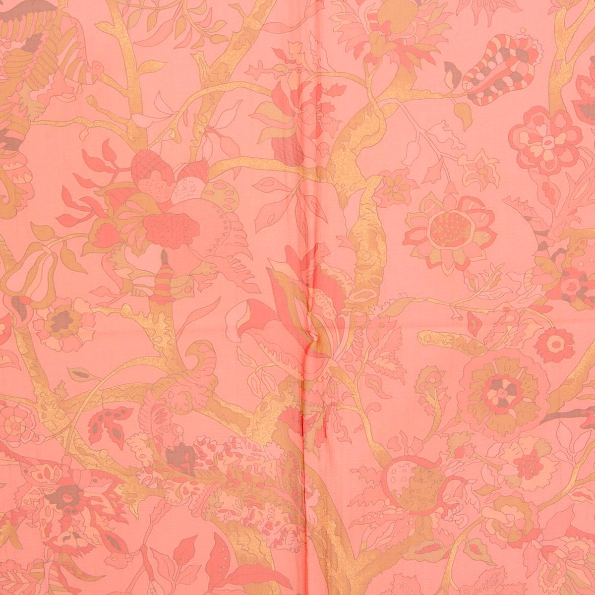 foulard 100% authentique Hermès Fantaisies Indiennes 140 Mousseline de Loic Dubiegon en mousseline de soie corail (100%). Il présente un motif élaboré de fleurs, d'animaux et de personnes sur un fond rose corail avec des détails en ocre, marron et