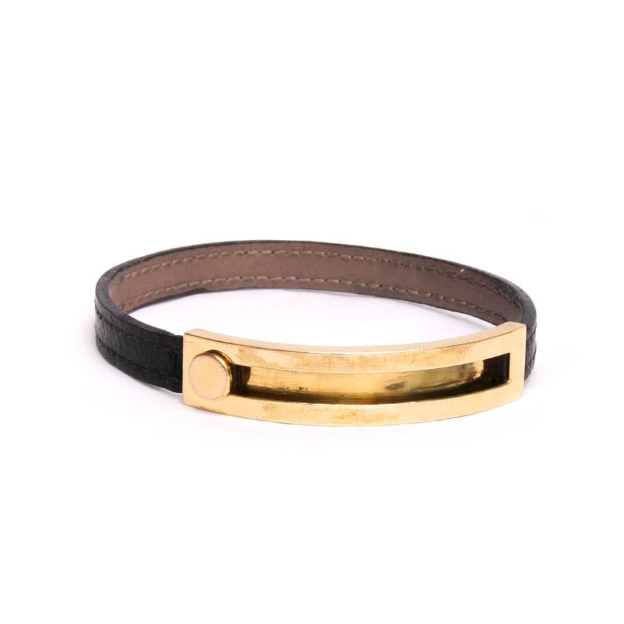 Hermès 'Coulisse' bracelet in brown Chamonix calf leather and 18 carat yellow gold. 

It is in very good condition.

The gold part has micro scratches of use. There is a sliding pusher that adjusts the bracelet from 19 cm to 23 cm. the height: 0.9