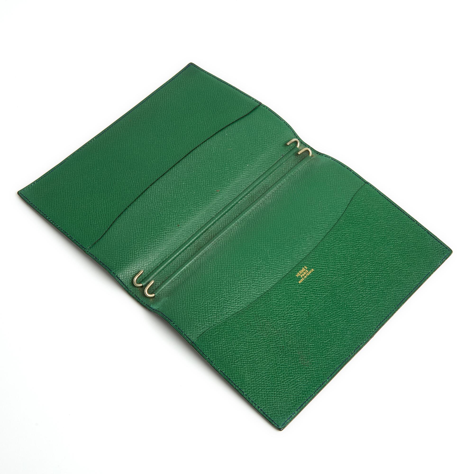 Hermès Globe Trotter diary cover in slightly grained and supple black leather on the outside, green leather interior with 2 large patch pockets and pairs of silver metal pins to hold the notebook, diary, directory ... Width 14 cm x height 19.5 cm.