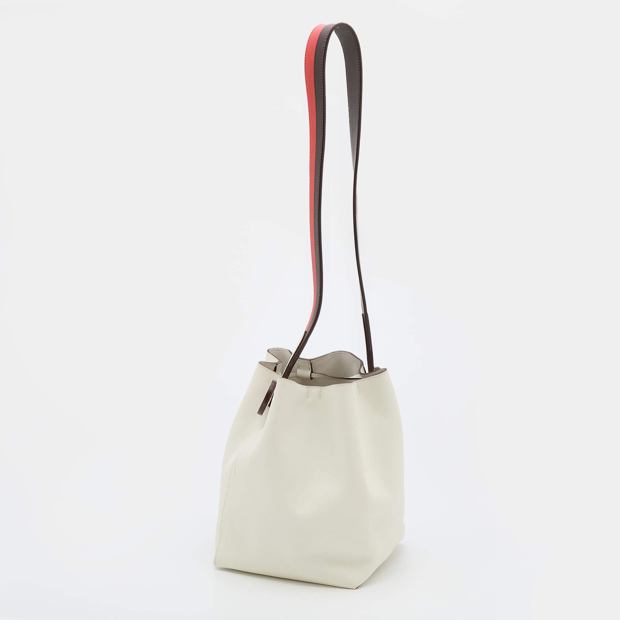 Crafted into an eye-catchy silhouette and style, this Licol bag from Hermes exudes just the right amount of charm and elegance! It is made from Craie Evercolor leather and is accentuated with a contrasting shoulder strap. It has a spacious