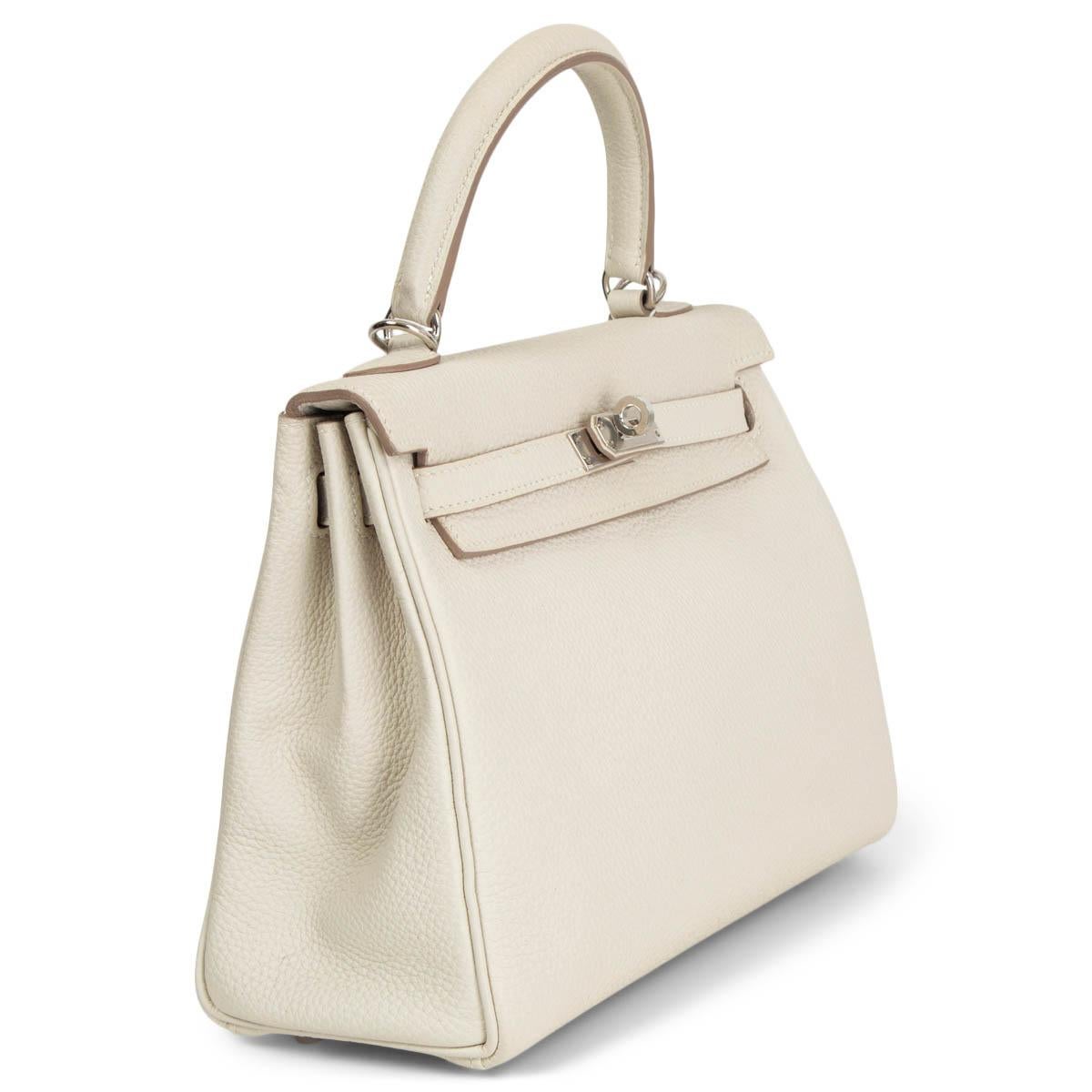100% authentic Hermès Kelly 25 Retourne bag in Craie (ivory) Veau Togo leather featuring palladium hardware. Lined in Chevre (goat skin) with an open pocket against the front and a zipper pocket against the back. Has been carried with a tiny scratch