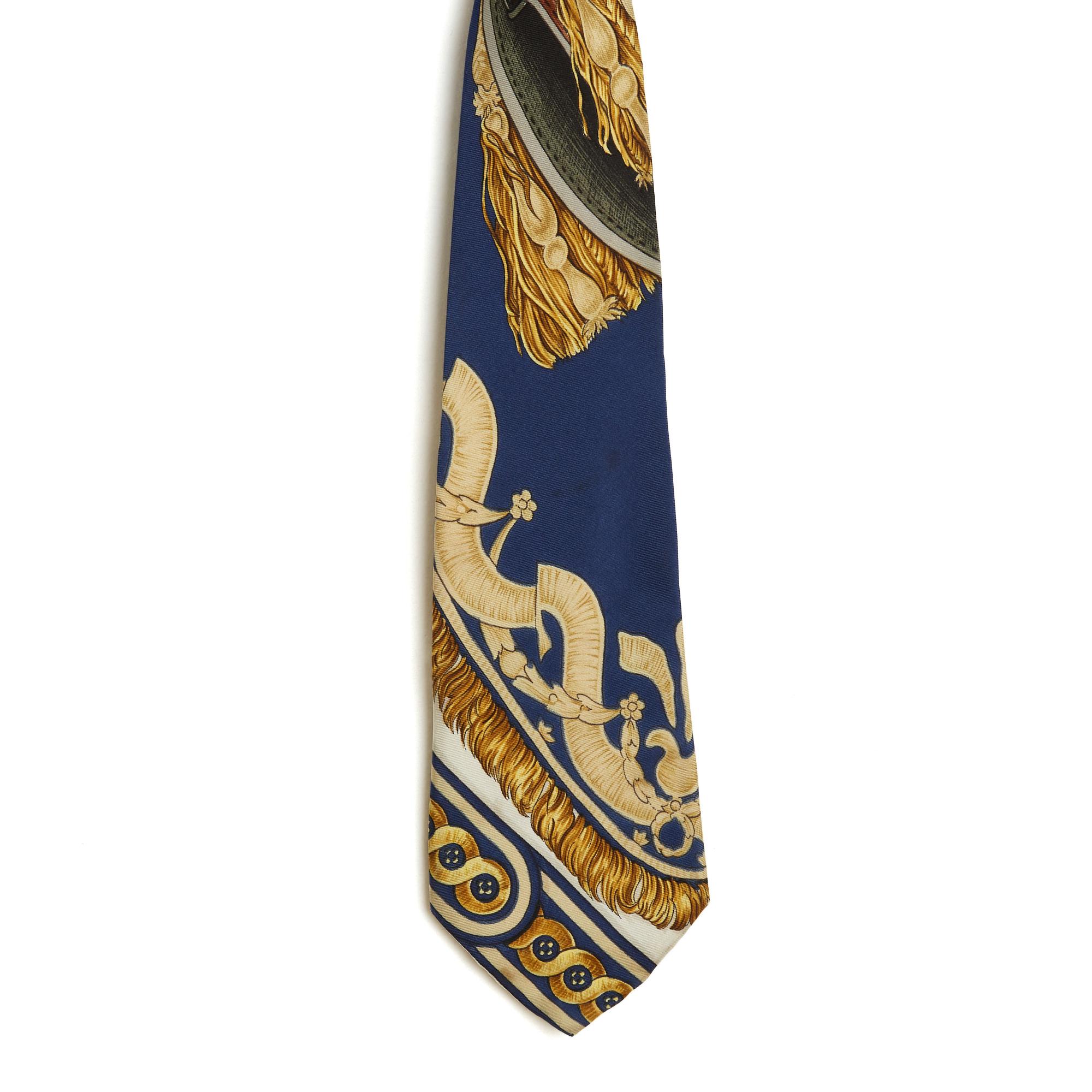 Cravate Hermès en sergé de soie avec le motif Bride de Cour de Françoise de la Perrière, créé en 1970 et réédité en 1987 (comme cette pièce) dans des tons de bleu, d'or et d'écru. La cravate est vintage mais reste en très bon état et est parfaite