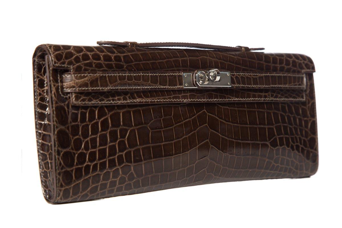 Hermès crocodile Kelly Cut Longue clutch
Tonal stitching
Palladium-plated hardware
Single top handle
Tonal leather interior lining
Turn-lock closure
Blind stamped Square Q from 2013
This item is previously worn with no major signs of wear. Item