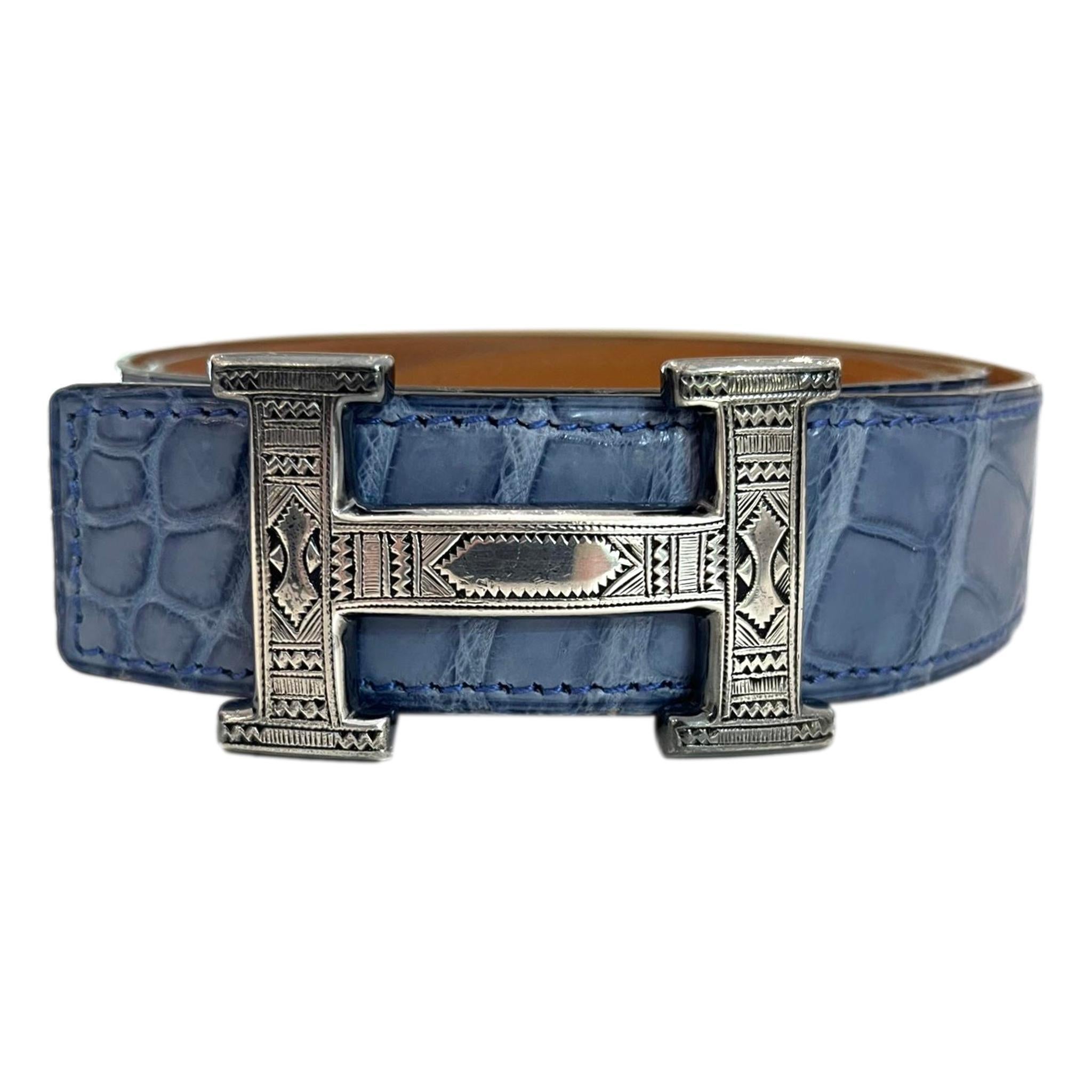 Hermes Crocodile Skin Belt With Solid Silver 'H' Touareg Large Buckle

Blue belt crafted in Porosus crocodile skin.

Detailed with large 'H' buckle in solid silver which is embellished with Aztec engraving.

Date stamp 2008

Size – 90cm

Condition –