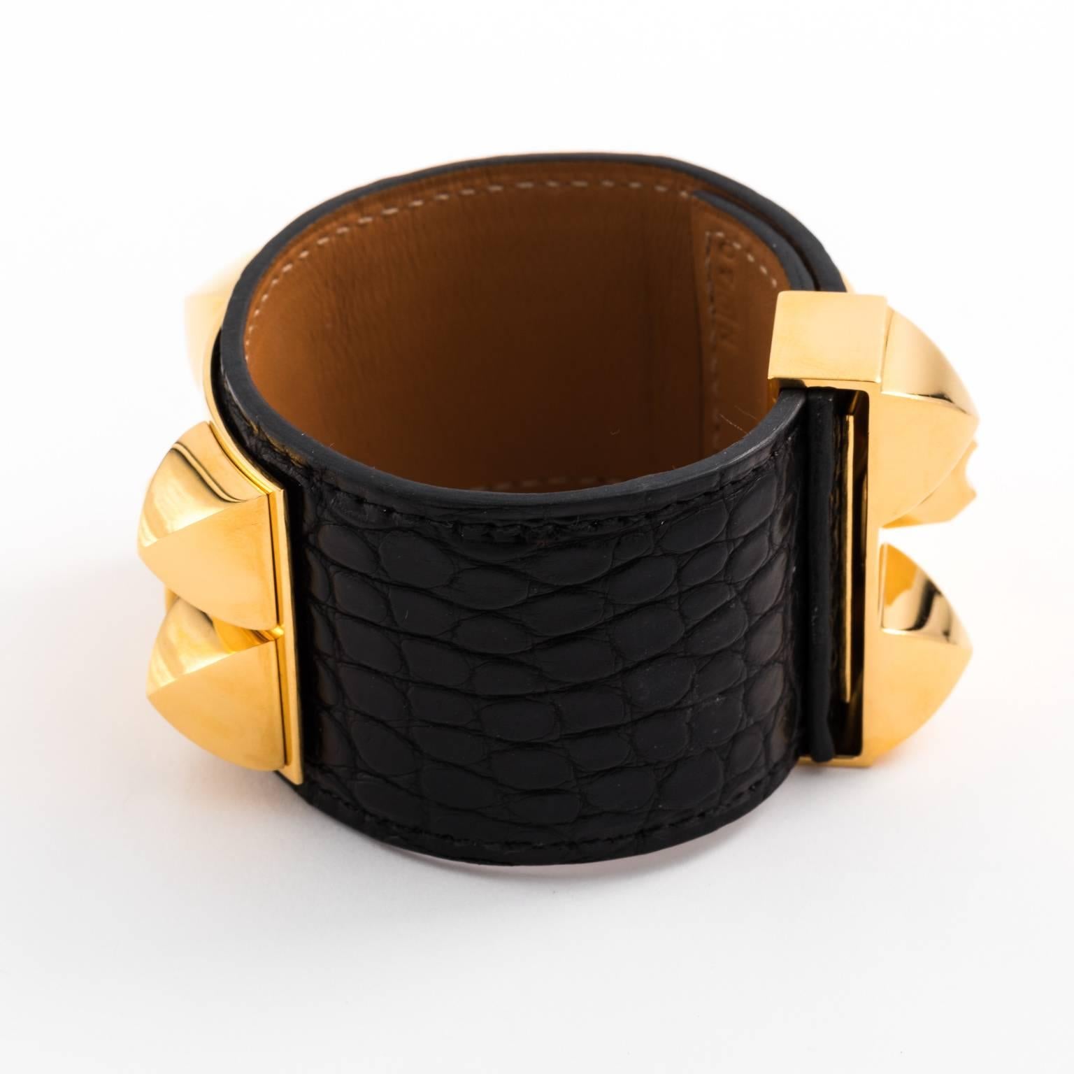 Contemporary Hermes Collier de Chien cuff bracelet that features a black alligator cuff with gold hardware. Size Medium.
