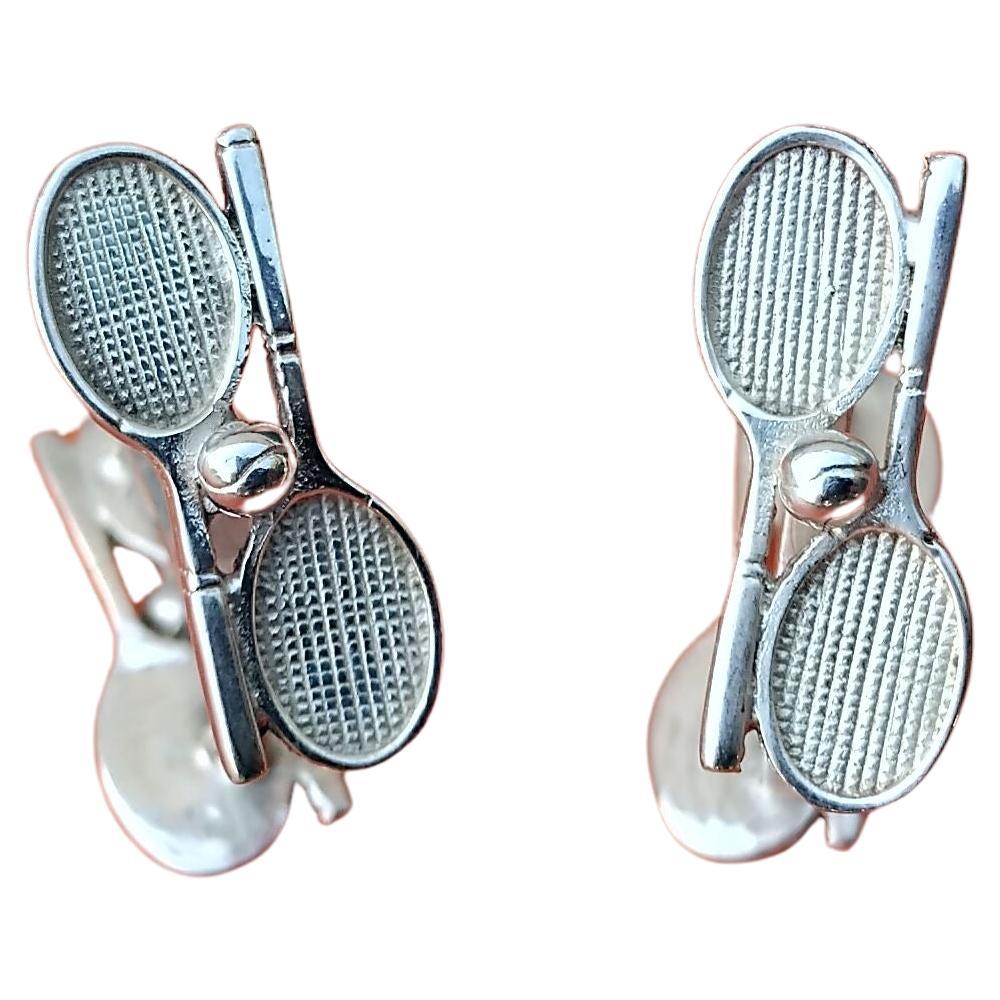 Boutons de manchette Hermès authentiques extrêmement rares

Chaque face en forme de deux raquettes et balles de tennis

Fabriqué en France

En argent sterling

Coloris : argenté

