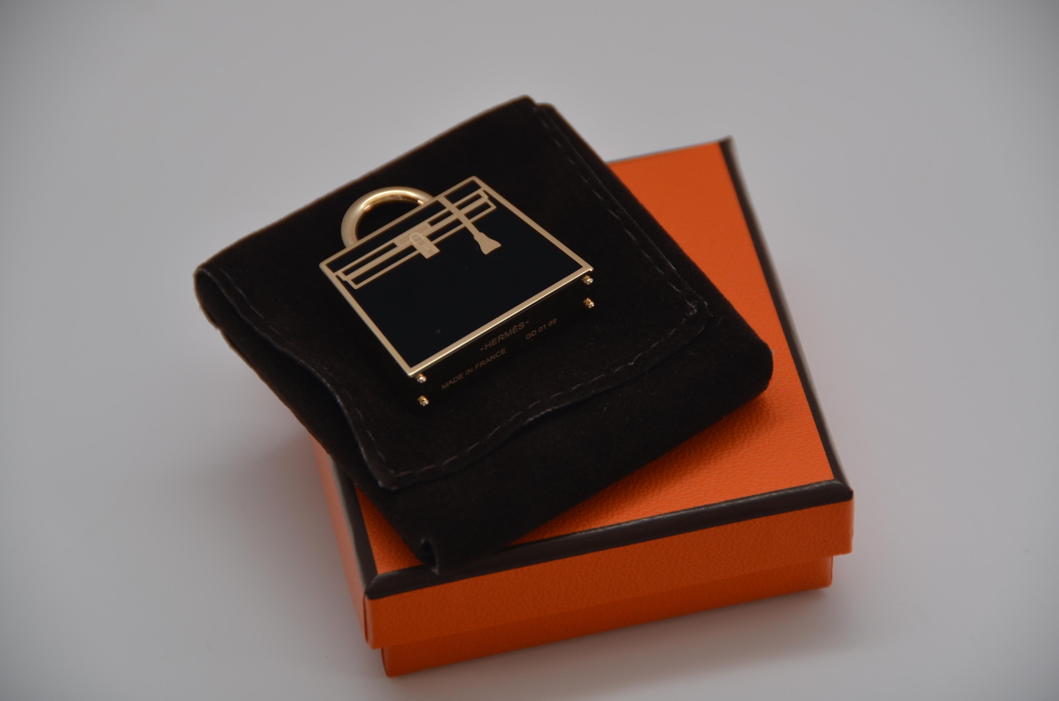 Guaranteed authentic Hermes Curiosite Kelly Laque charm  Black with in Gold tone . 
Shaped like a Kelly Bag, the charm is beautifully detailed! 
Designed as a necklace pendant, and can also be worn tied to an Hermes Twilly as a charm. 
Stamped