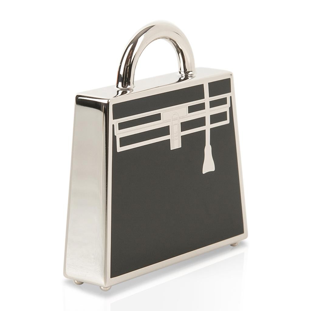 Guaranteed authentic Hermes Curiosite Kelly Laque charm features Black with Palladium.
Shaped like a Kelly Bag, the charm is beautifully detailed!
Designed as a necklace pendant, and can also be worn tied to an Hermes Twilly as a charm.
Stamped