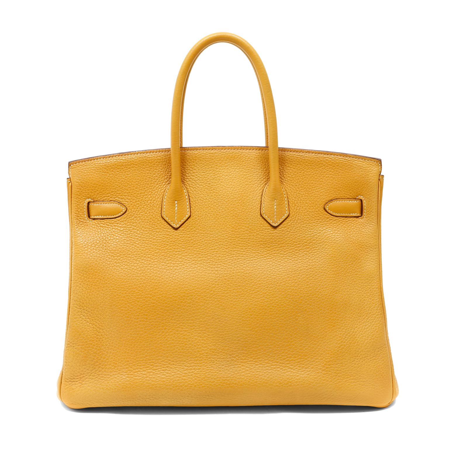 This authentic Hermès Curry yellow Clemence 35cm Birkin is in pristine condition with the protective plastic on the hardware. Hermès bags are considered the ultimate luxury item the world over.  Hand stitched by skilled craftsmen, wait lists of a