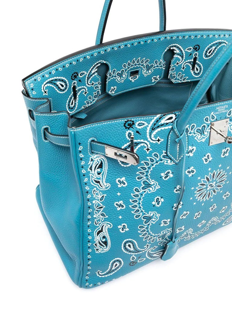 This one of a kind Hermès Birkin in Blue Jean features a white intricate bandana print. Its blue leather facade is offset with Palladium hardware, and the handbag's interior holds a large zipped pocket and an open pochet, making it as practical as