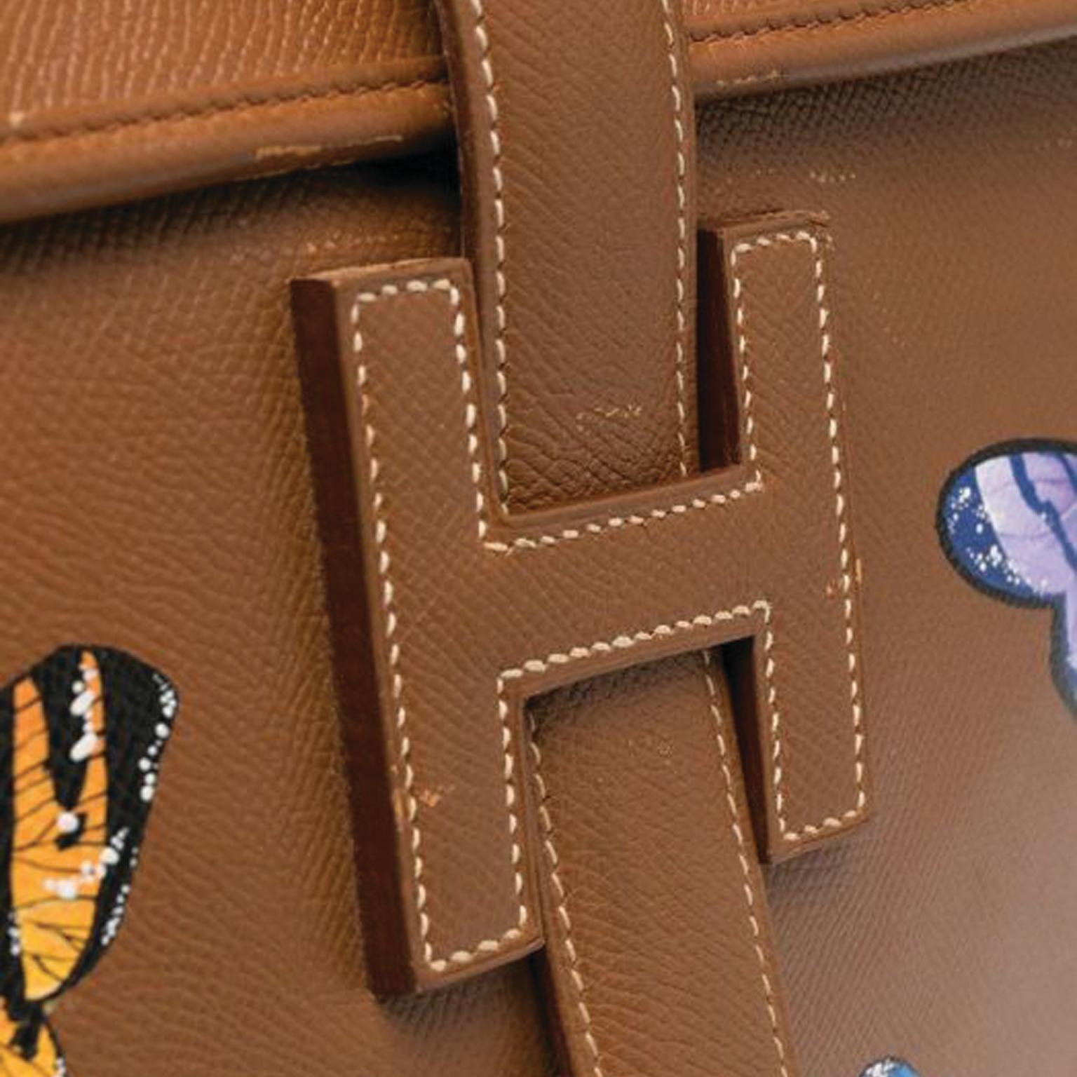 Hermès Vintage Jige GM Clutch Bag in Brown Courchevel leather, lined with beige canvas. The front has a flap with the Hermes H in the front to slip a strap through and decorated with painted butterflies. 

Colour: Brown & Multi-colour	

Composition: