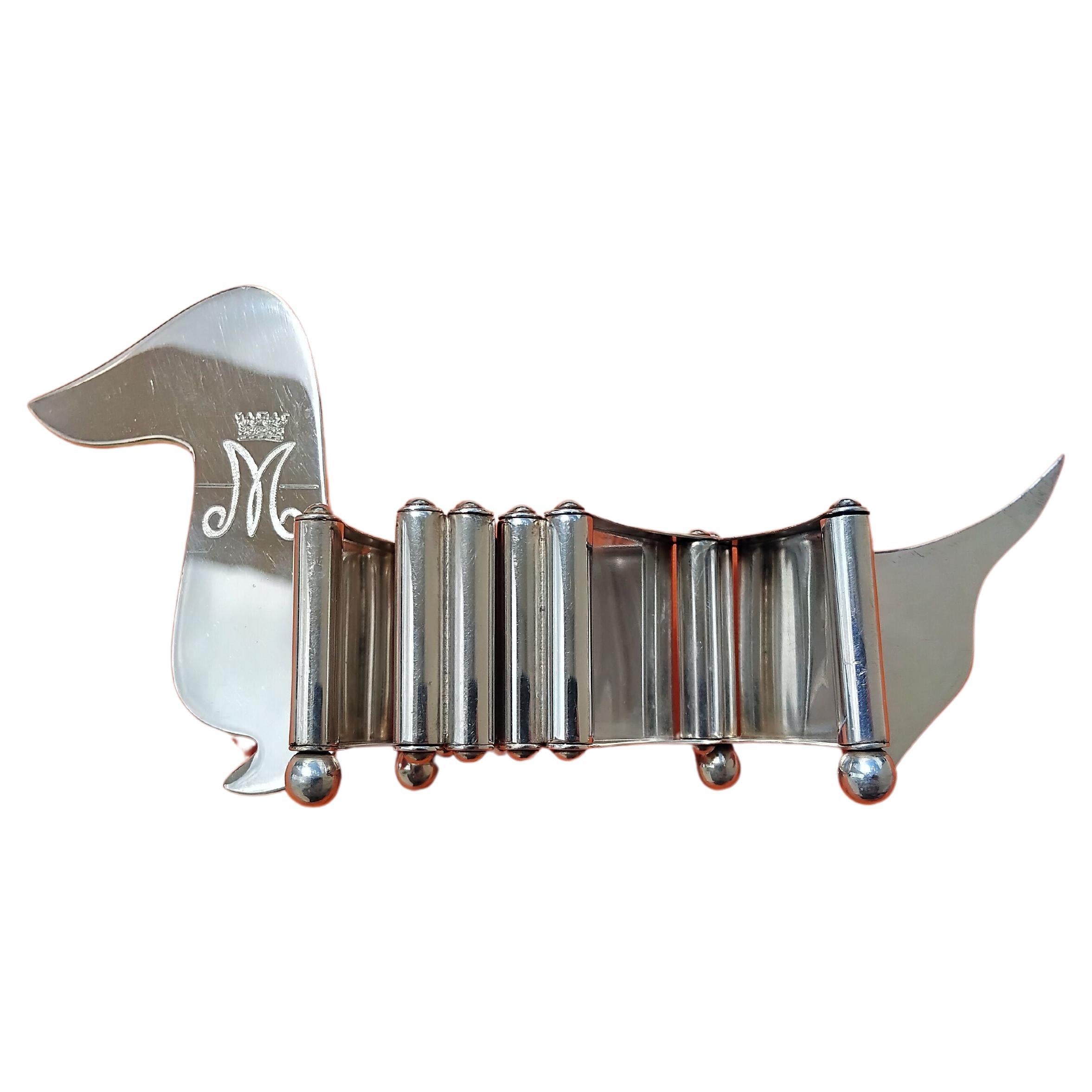 Exceptionnel et rarissime cadre photos Hermès authentique

Absolument magnifique, une véritable pièce de collection pour tous les amoureux d'Hermès et du Teckel !

En forme de Teckel, le corps est constitué de 6 petits cadres photo articulés, reliés