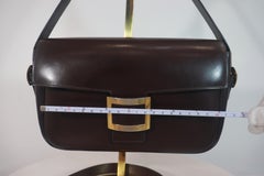 HERMÈS Dark Brown Leather Crossbody Bag with Gold Buckle and Adjustable Strap