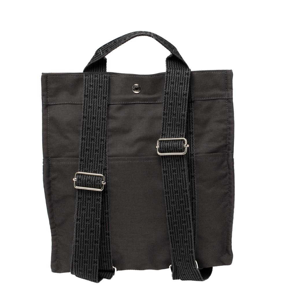 Hermes Herline backpack can easily hold all your day-to-day essentials. It has been crafted from a grey canvas body and secured with a snap button closure. It comes with a flat top handle as well as rear shoulder straps. Carry it for busier