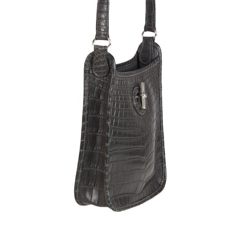 Hermès Vespa TPM Mini in matte dark grey crocodile. Opens with a long, metal piece which inserts into a buttonhole and functions as a clasp. Lined in grey calf leather. Has been carried and is in excellent condition.

Height 18cm (7in)
Width 18cm