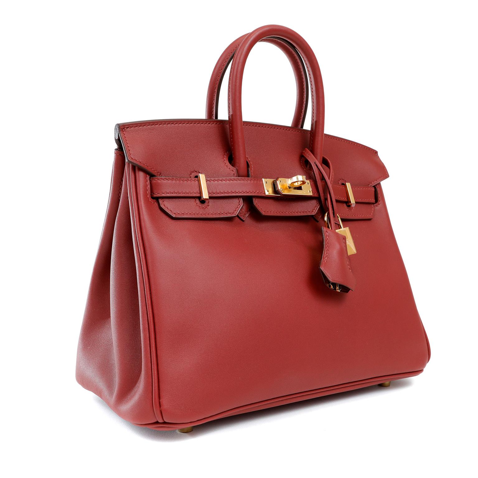 This authentic Hermès Dark Red Swift Leather 25 cm Birkin Bag is in pristine unworn condition with plastic intact on the hardware.  Long waitlists are commonplace for the intensely coveted classic leather Birkin bag.  Each piece is hand crafted by