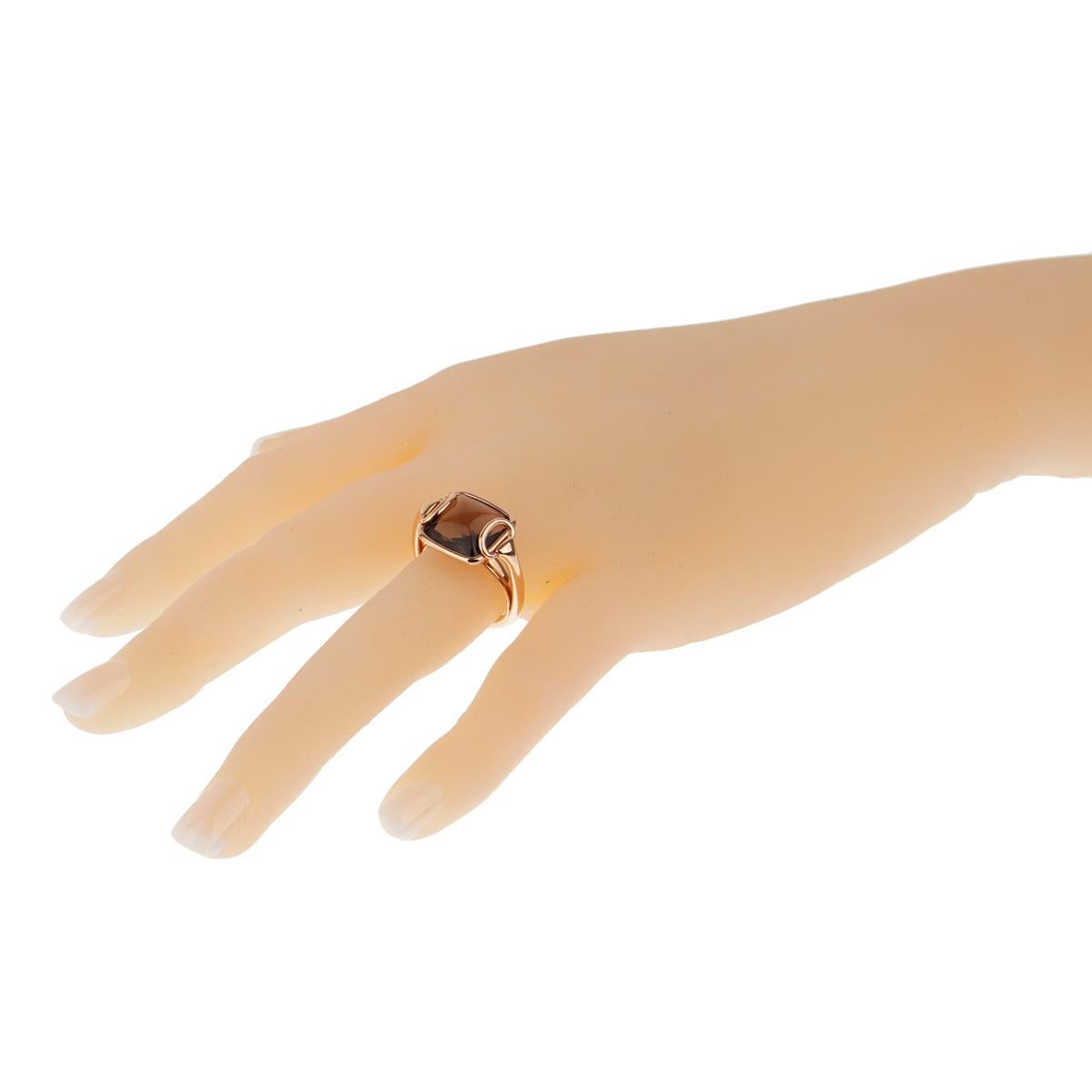 A simple and elegant Hermes cocktail ring from the Deux Anneaux collection. A rich, faceted, square smoky quartz gemstone is set in a 18kt rose gold bezel and embellished with two delicate rose gold loops.

Size: 6 1/4 Width: .55